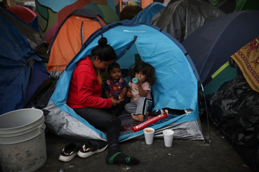 Mexican Amary Martinez, and her children, Jason and Itzel, sit on the edge of their tent at a migrant camp near El Chaparral pedestrian border bridge in Tijuana, Mexico, Friday, July 2, 2021. The migrant camp of about 2,000 asylum-seekers, mostly families, blocks a pedestrian entrance to the US border crossing with San Diego. Mexican officials have suggested they will try to relocate them in coming days in anticipation that the two governments could agree to reopen the border to non-essential travel in the coming weeks. (AP Photo/Emilio Espejel)