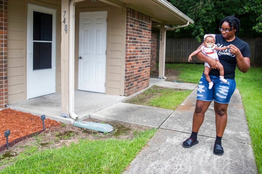 Tyesha Young, who lost her hospital job during the pandemic, holds her baby Jalayah Johnson outside their home in Waggaman, La., Friday, July 2, 2021. (AP Photo/Sophia Germer)