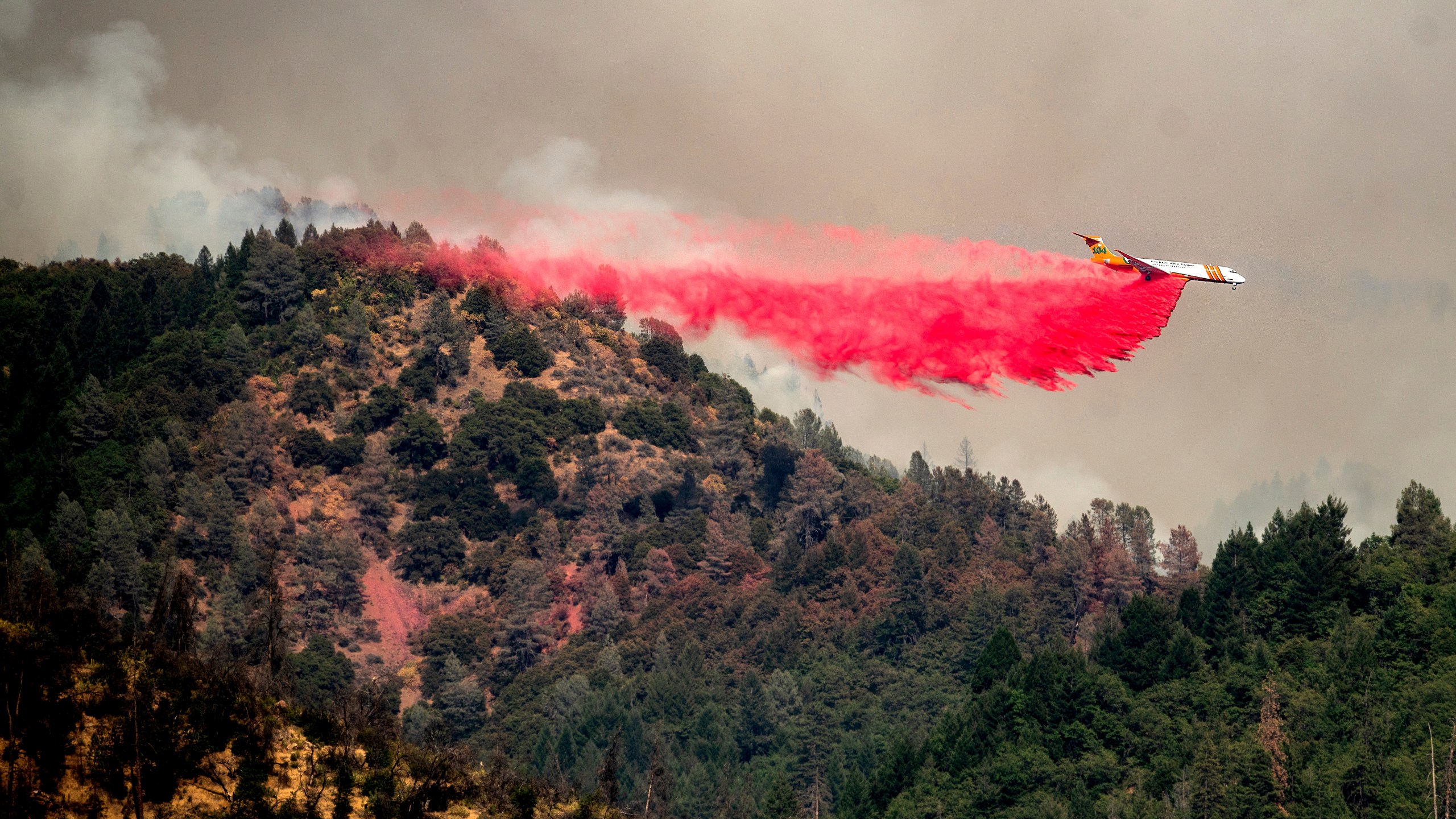 An air tanker drops retardant while trying to stop the Salt Fire from spreading near Lakehead in unincorporated Shasta County, Calif., on July 2, 2021. (Noah Berger / Associated Press)