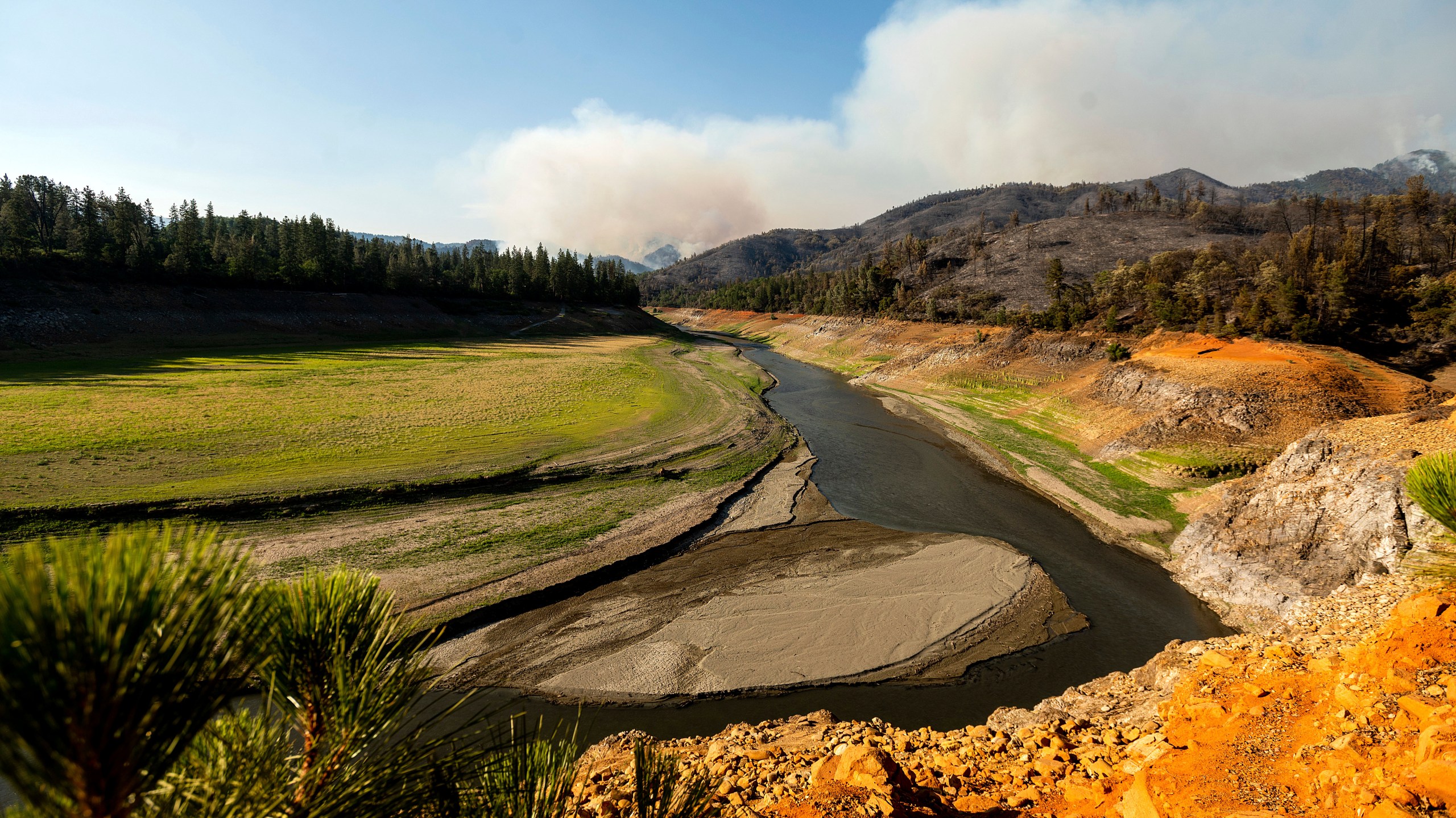 Smoke from the Salt Fire rises above Lake Shasta, which was at 38 percent of capacity at the time of this photo, on Friday, July 2, 2021, in unincorporated Shasta County, Calif. (AP Photo/Noah Berger)