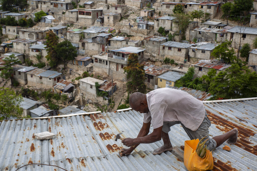 Antony Exilien secures the roof of his house in response to Tropical Storm Elsa, in Port-au-Prince, Haiti, Saturday, July 3, 2021. (AP Photo/Joseph Odelyn)