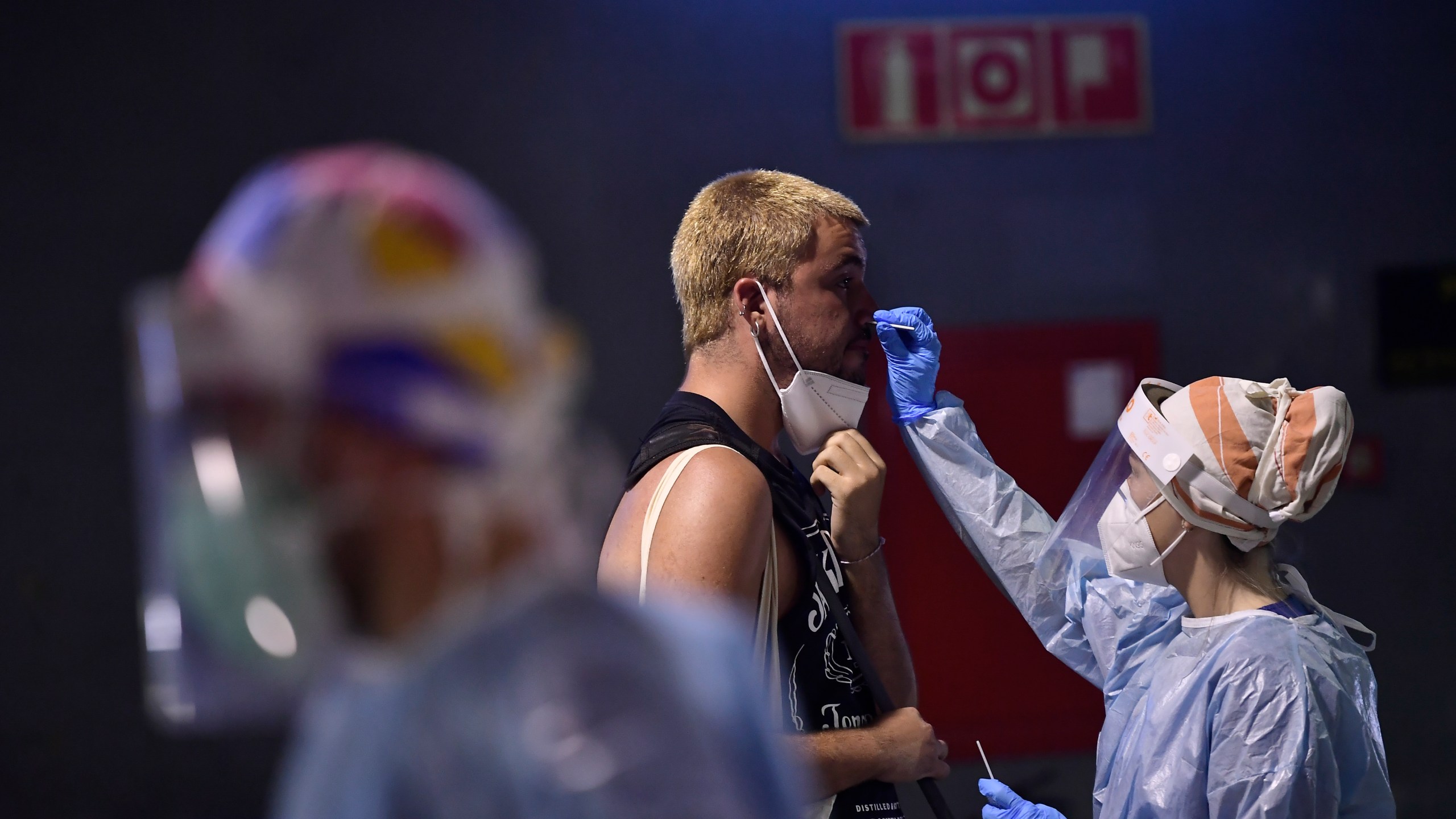 A health worker takes a swab from a teenager during a rapid antigen test for COVID-19 at bus station in Pamplona, northern Spain, on July 4, 2021. (Alvaro Barrientos / Associated Press)