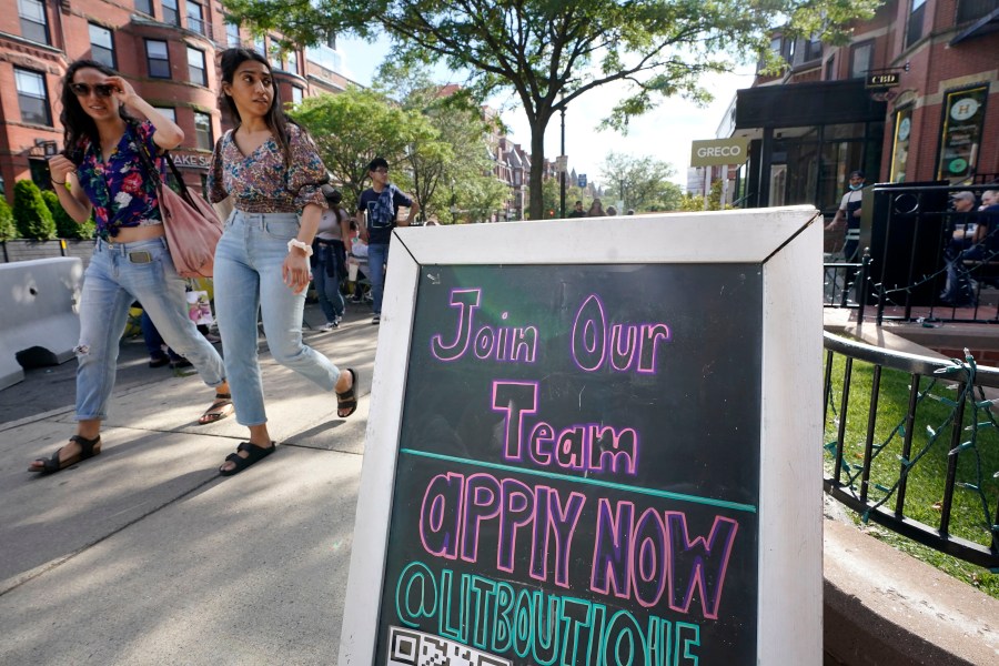 Pedestrians walk past a sign inviting people to apply for employment at a shop in Boston's fashionable Newbury Street neighborhood, Monday, July 5, 2021. As the U.S. economy bounds back with unexpected speed from the pandemic recession and customer demand intensifies, high school-age kids are filling jobs that older workers can’t — or won’t. (AP Photo/Steven Senne)