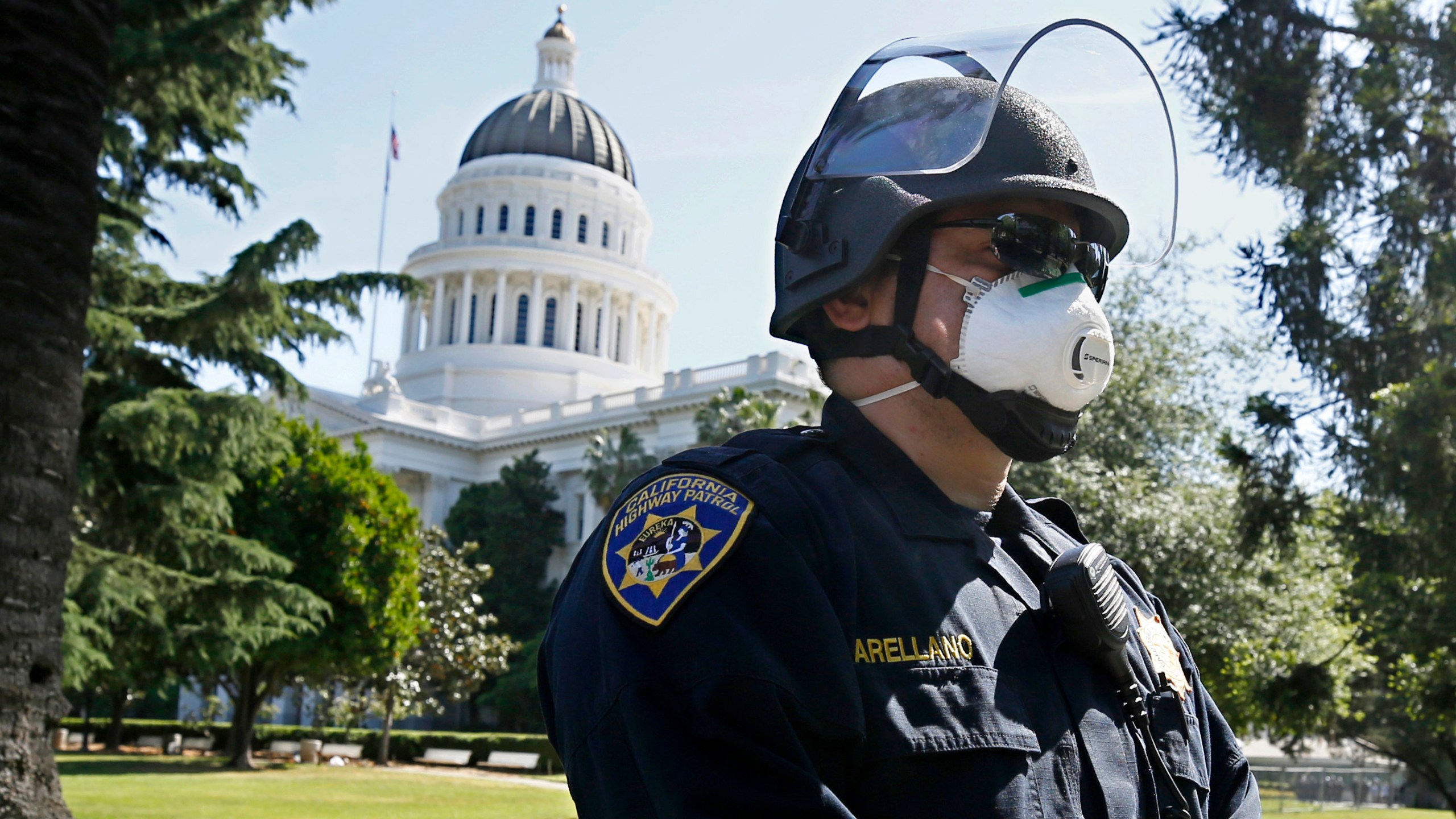 California Highway Patrol Officer S. Arellano wears a face mask as he and other officers form a line in anticipation of a protest at the the state Capitol in Sacramento on May 7, 2020. (Rich Pedroncelli / Associated Press)