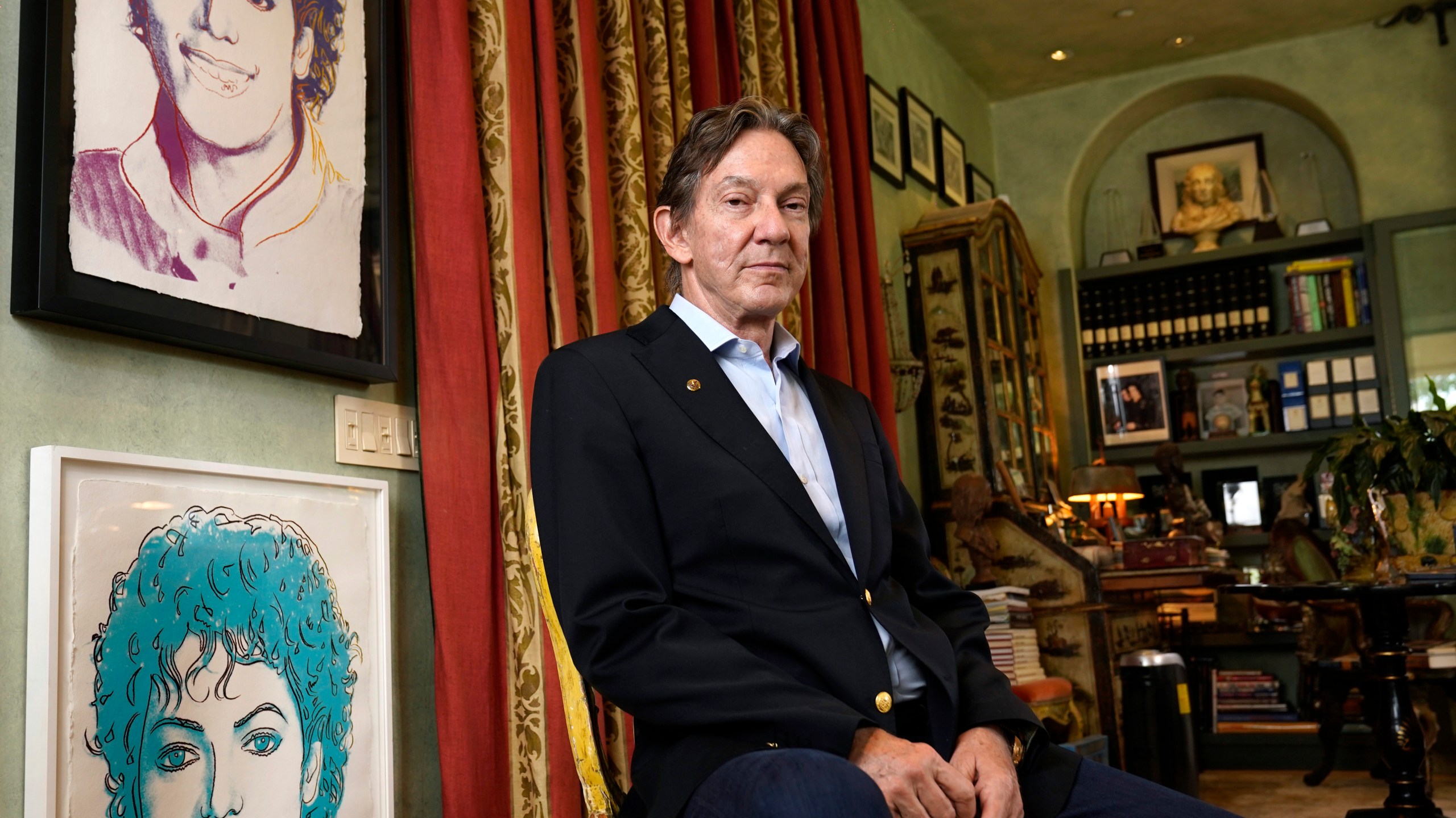 Entertainment lawyer and Michael Jackson Estate co-executor John Branca poses for a portrait alongside Andy Warhol prints of Jackson on July 8, 2021, at his home in Los Angeles. (Chris Pizzello/Associated Press)