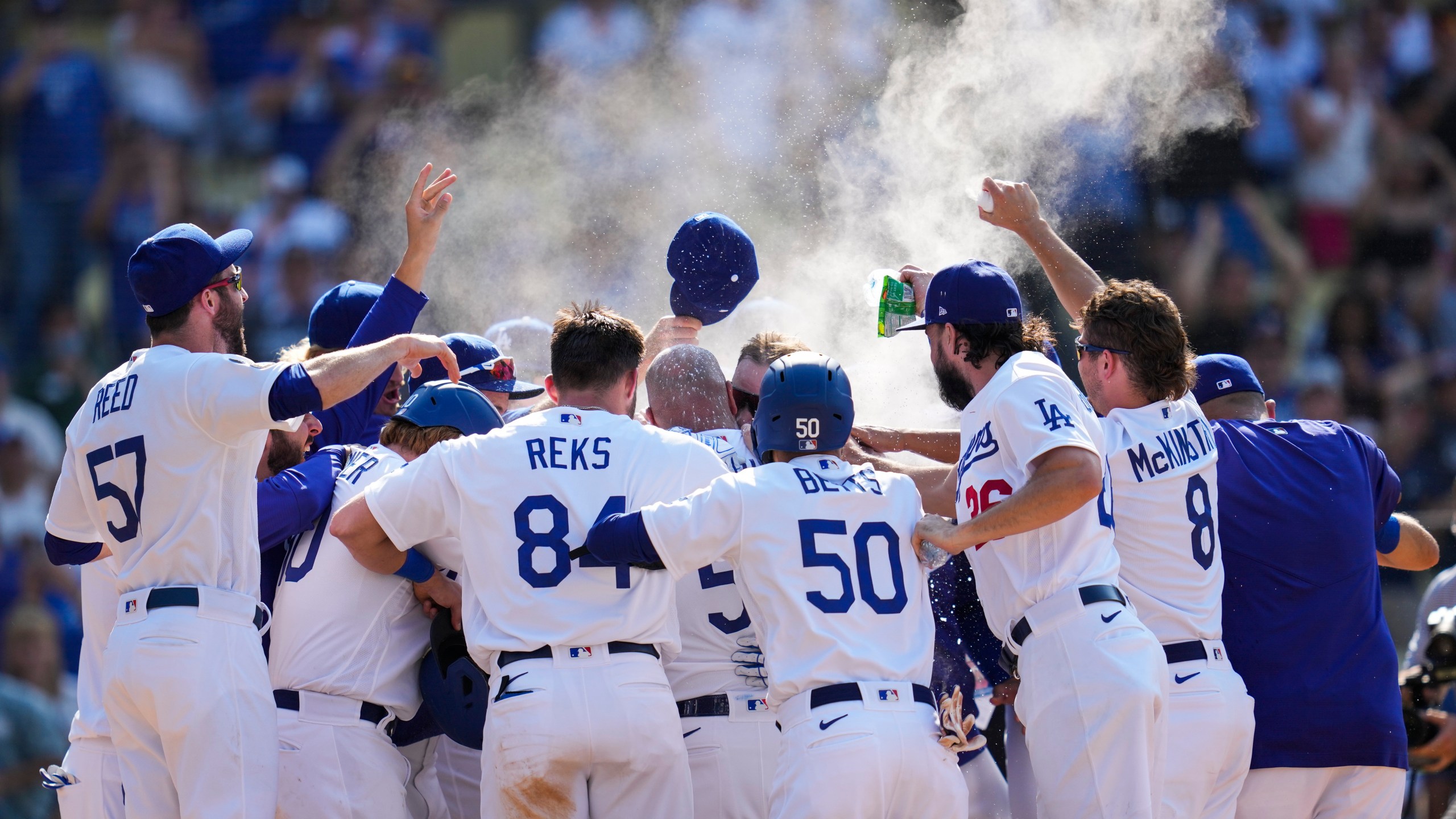 The Los Angeles Dodgers celebrate after Max Muncy hit a home run during the ninth inning of a baseball game against the Arizona Diamondbacks Sunday, July 11, 2021, in Los Angeles. Zach Reks and Mookie Betts also scored. The homer won the game for the Dodgers 7-4. (AP Photo/Ashley Landis)