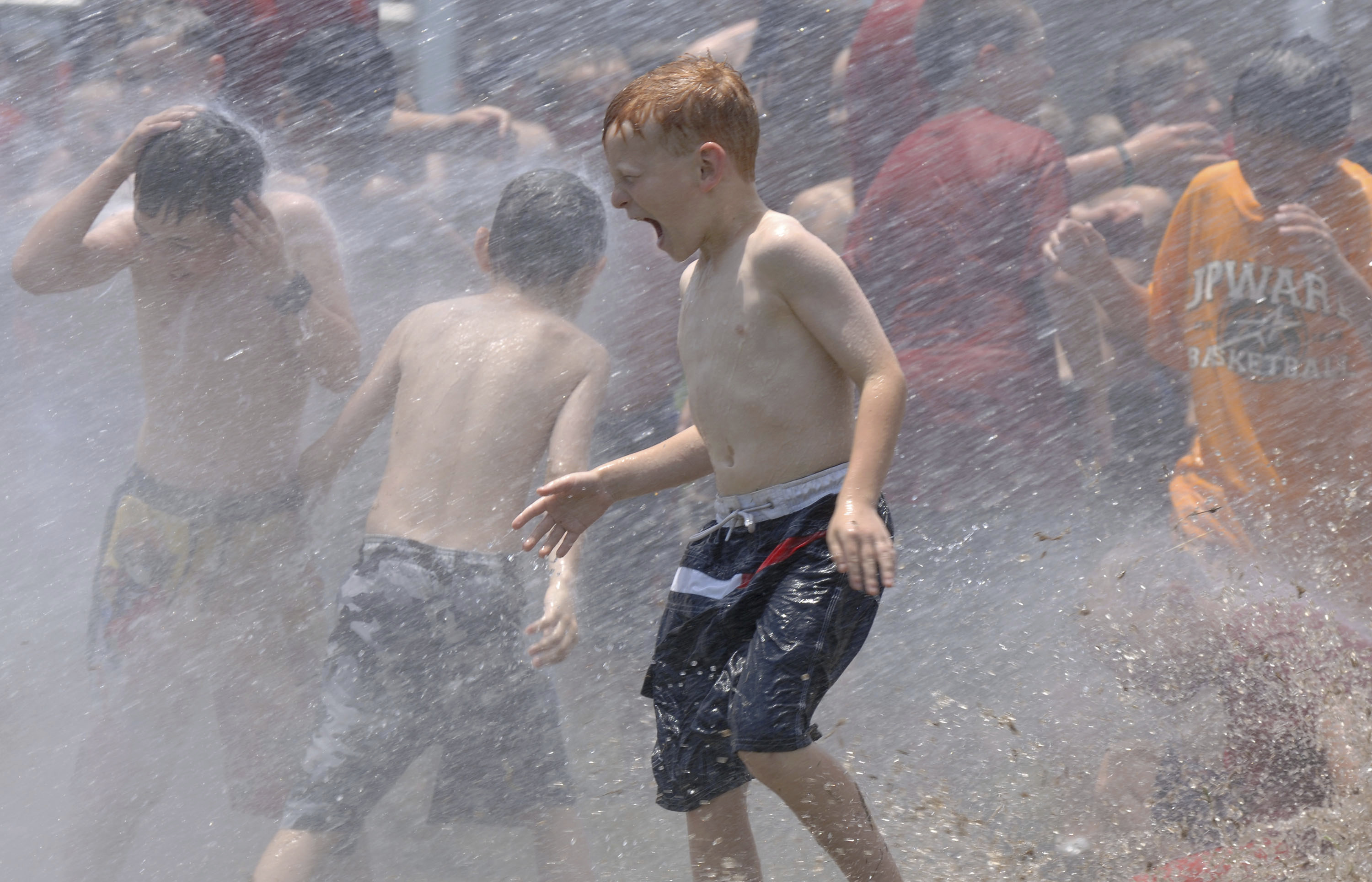 In this June 9, 2006, file photo, kids from a day camp get soaked by the the fire department at Tyler Junior College in Tyler, Texas. The U.S. has seen a string of COVID-19 outbreaks tied to summer camps in recent weeks in Texas, Illinois, Florida, Missouri and Kansas, offering what some fear could be a preview of the upcoming school year. (Brad Smith/Tyler Morning Telegraph via AP, File)