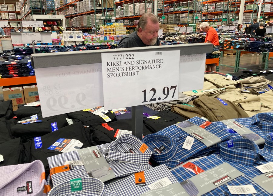 A sign displays the price for shirts as a shopper peruses the offerings at a Costco warehouse on Thursday, June 17, 2021, in Lone Tree, Colo. American consumers faced a third straight monthly surge in princes in June, the latest sign that a rapid reopening of the economy is fueling a pent-up demand for goods and services that in many cases remain in short supply. (AP Photo/David Zalubowski)