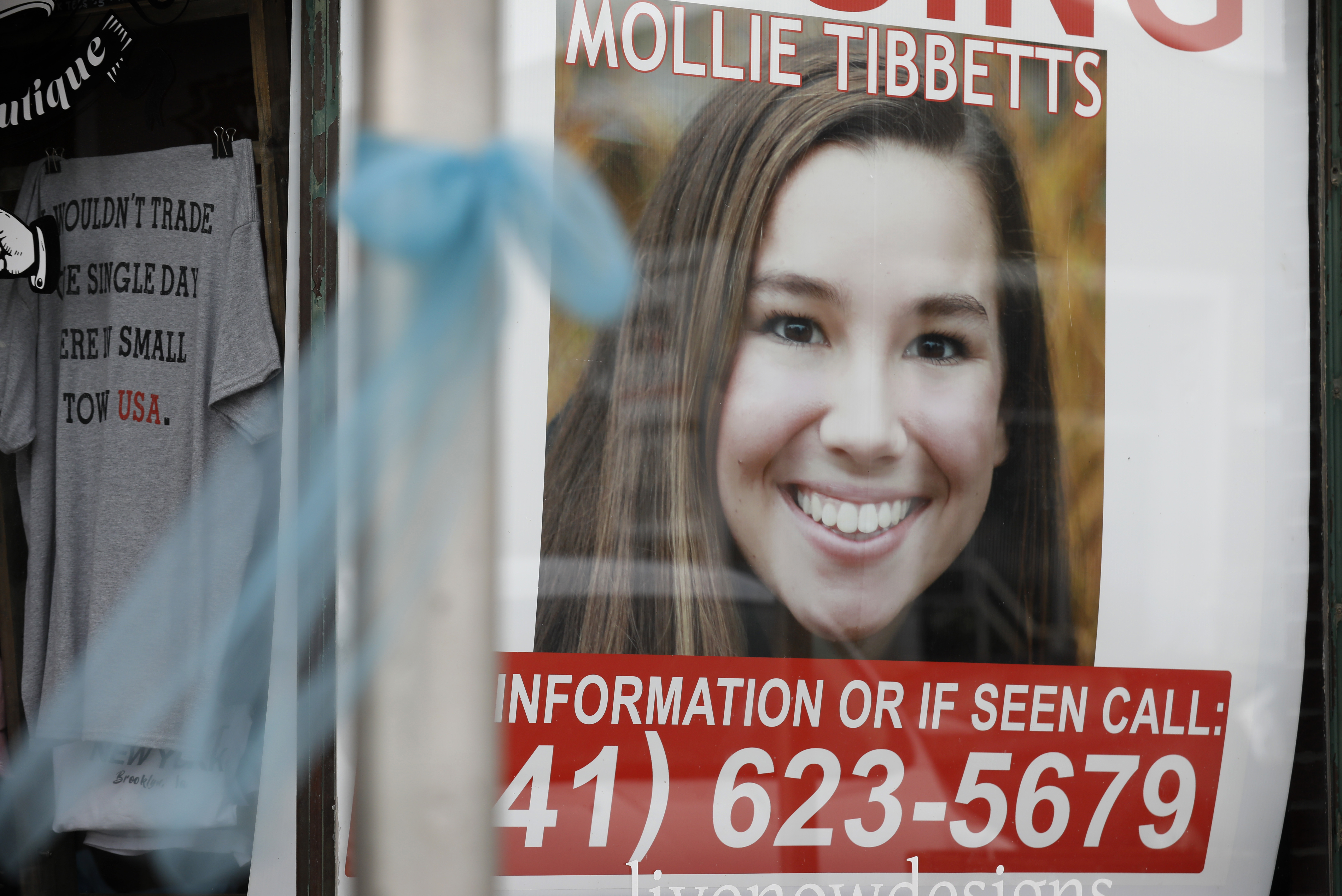 A poster for missing University of Iowa student Mollie Tibbetts hangs in the window of a local business in Brooklyn, Iowa, on Aug. 21, 2018. (Charlie Neibergall / Associated Press)