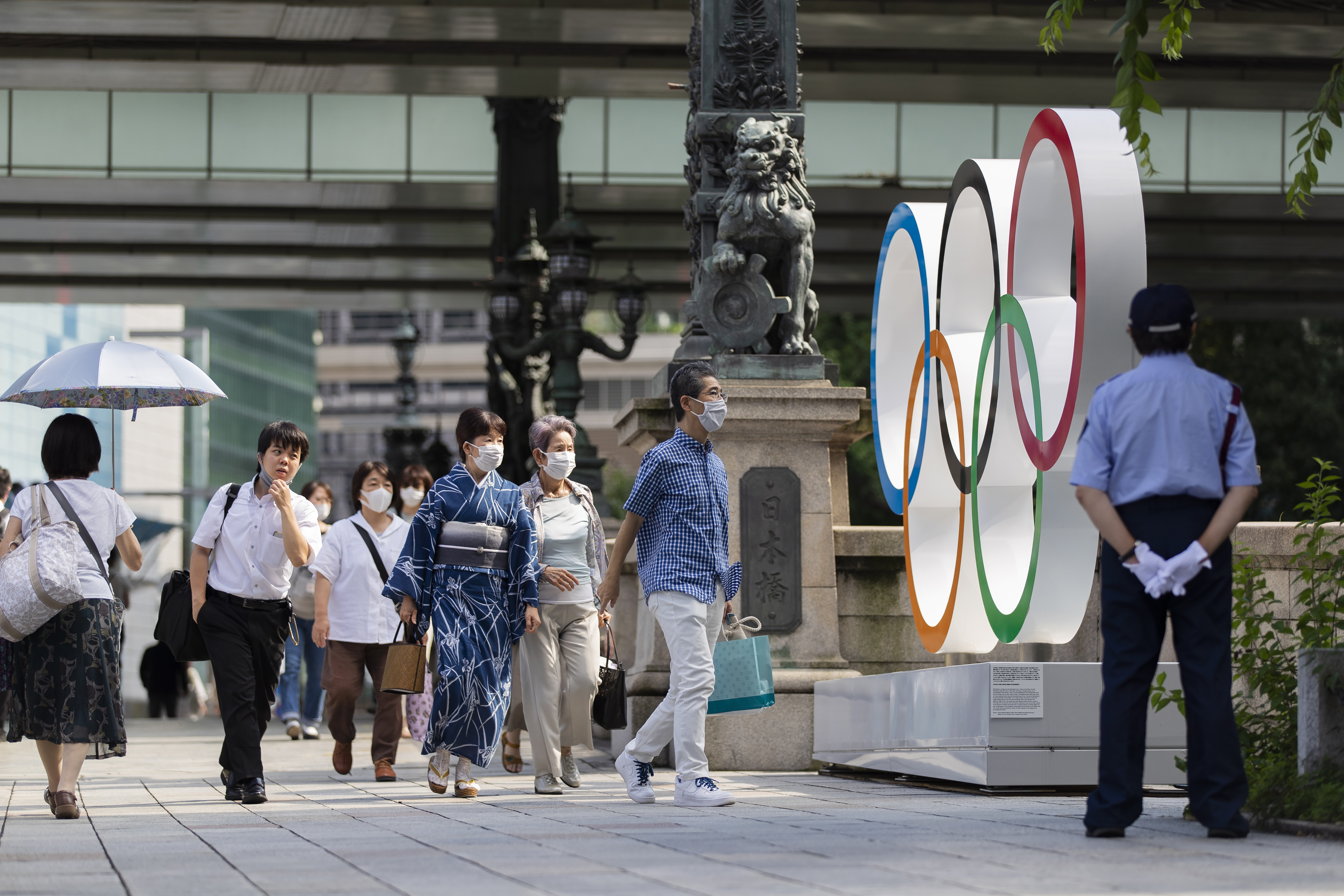 People walk by the Olympic rings installed by the Nippon Bashi bridge in Tokyo on Thursday, July 15, 2021. (Hiro Komae/Associated Press)