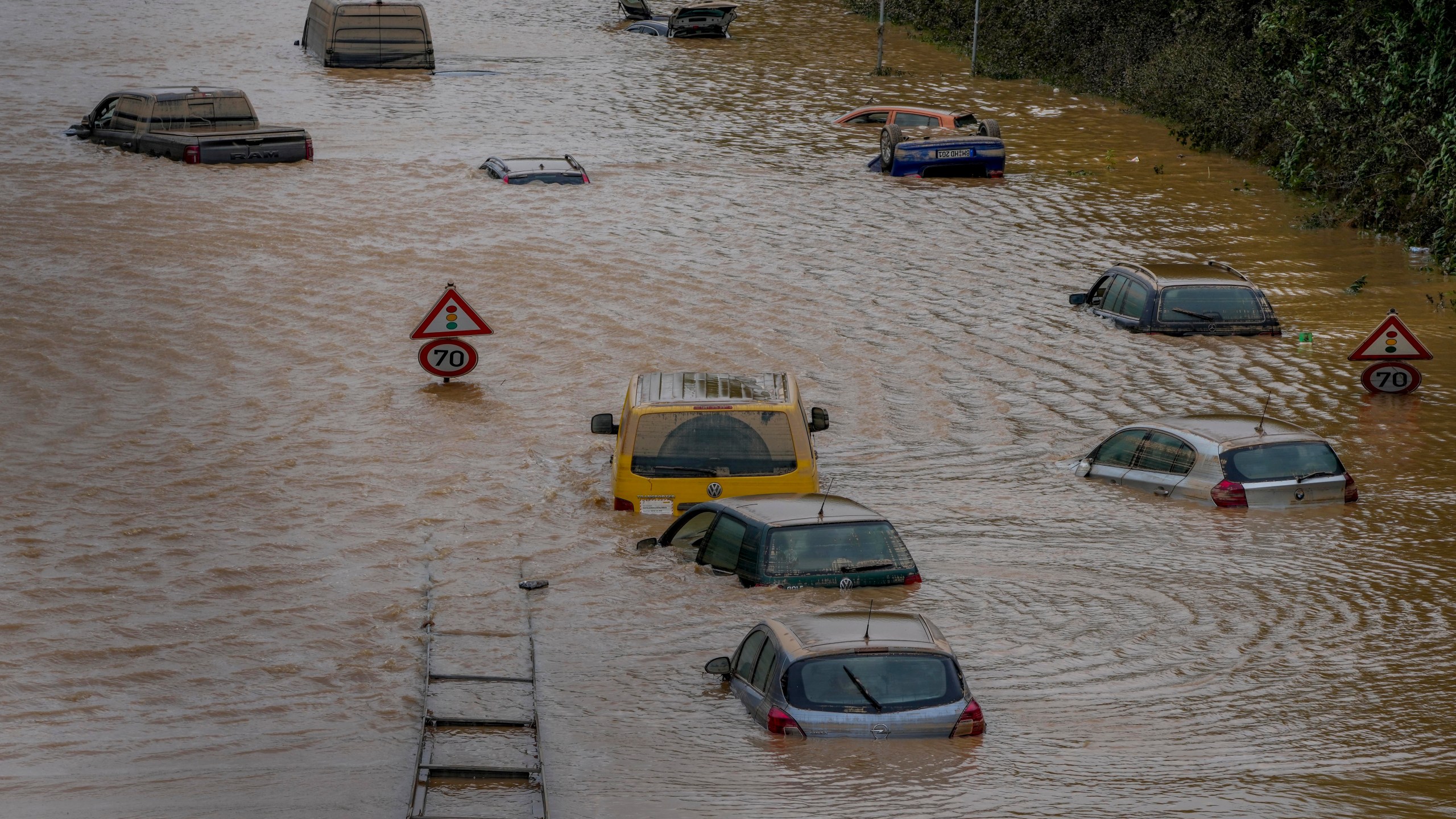 Cars show up as the flood sinks on a road in Erftstadt, Germany, Saturday, July 17, 2021. Due to strong rain falls the small Erft river went over the banks causing massive damages. (AP Photo/Michael Probst)