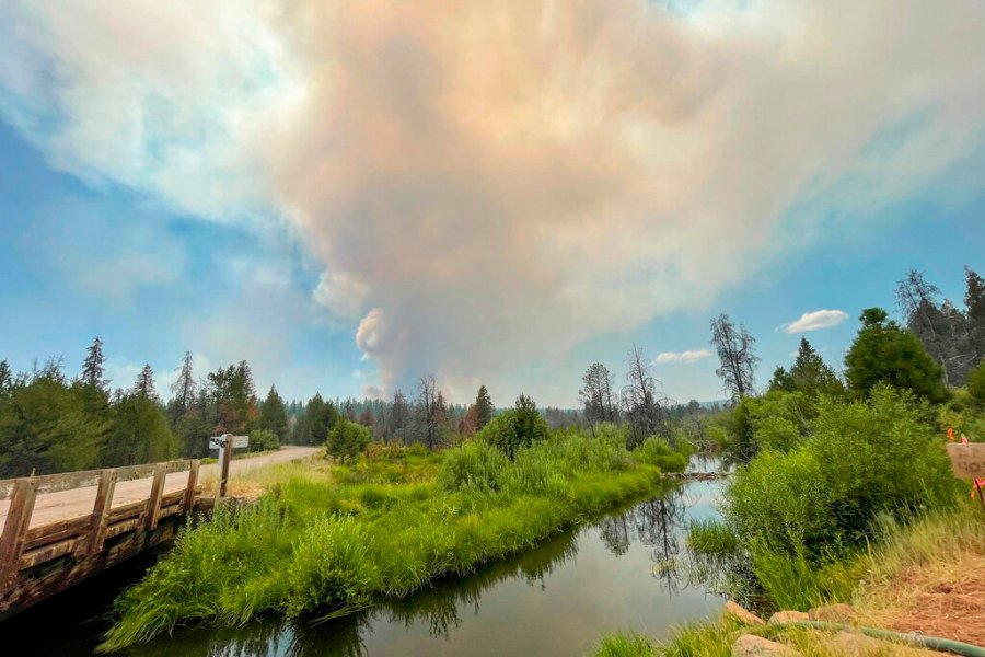 In this photo provided by the Bootleg Fire Incident Command, the Bootleg Fire burns in the background behind the Sycan Marsh in southern Oregon on Saturday, July 17, 2021. (Bootleg Fire Incident Command via AP)