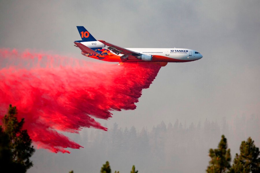 In this photo provided by the Bootleg Fire Incident Command, a DC-10 tanker drops retardant over the Bootleg Fire in southern Oregon, Thursday, July 15, 2021. (Bootleg Fire Incident Command via AP)