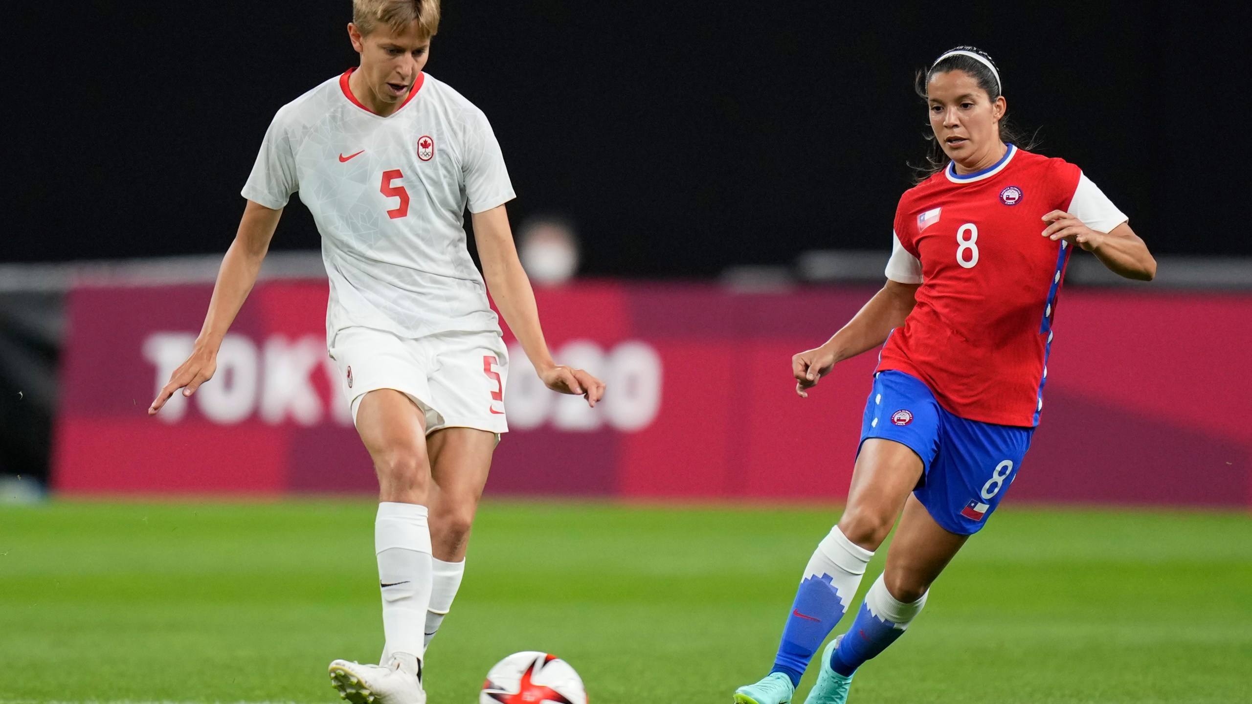 Canada's Quinn, left, and Chile's Karen Araya vie for the ball during a women's soccer match at the 2020 Summer Olympics, Saturday, July 24, 2021, in Sapporo, Japan. (AP Photo/Silvia Izquierdo)