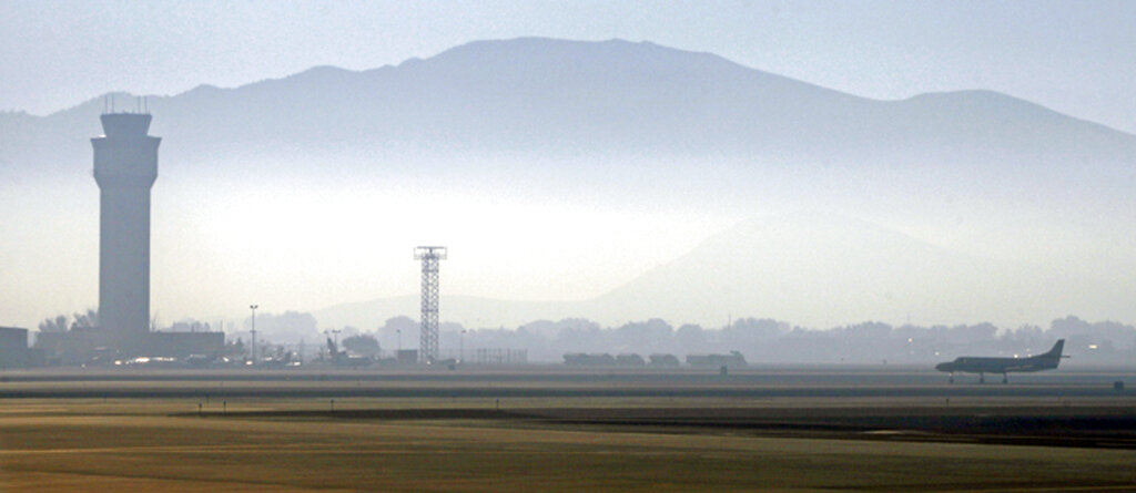 In this Sept. 24, 2014 file photo, smoke hangs over Reno-Tahoe International Airport as a plane takes off in Reno, Nevada. (AP Photo/Martha Irvine, File)