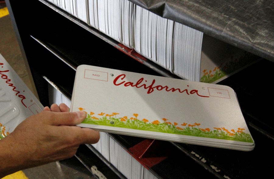 In this May 15, 2012, file photo an inmate gets some blank KIDS specialty license plates to be made through the prison industries program at Folsom State Prison. (Rich Pedroncelli/Associated Press)