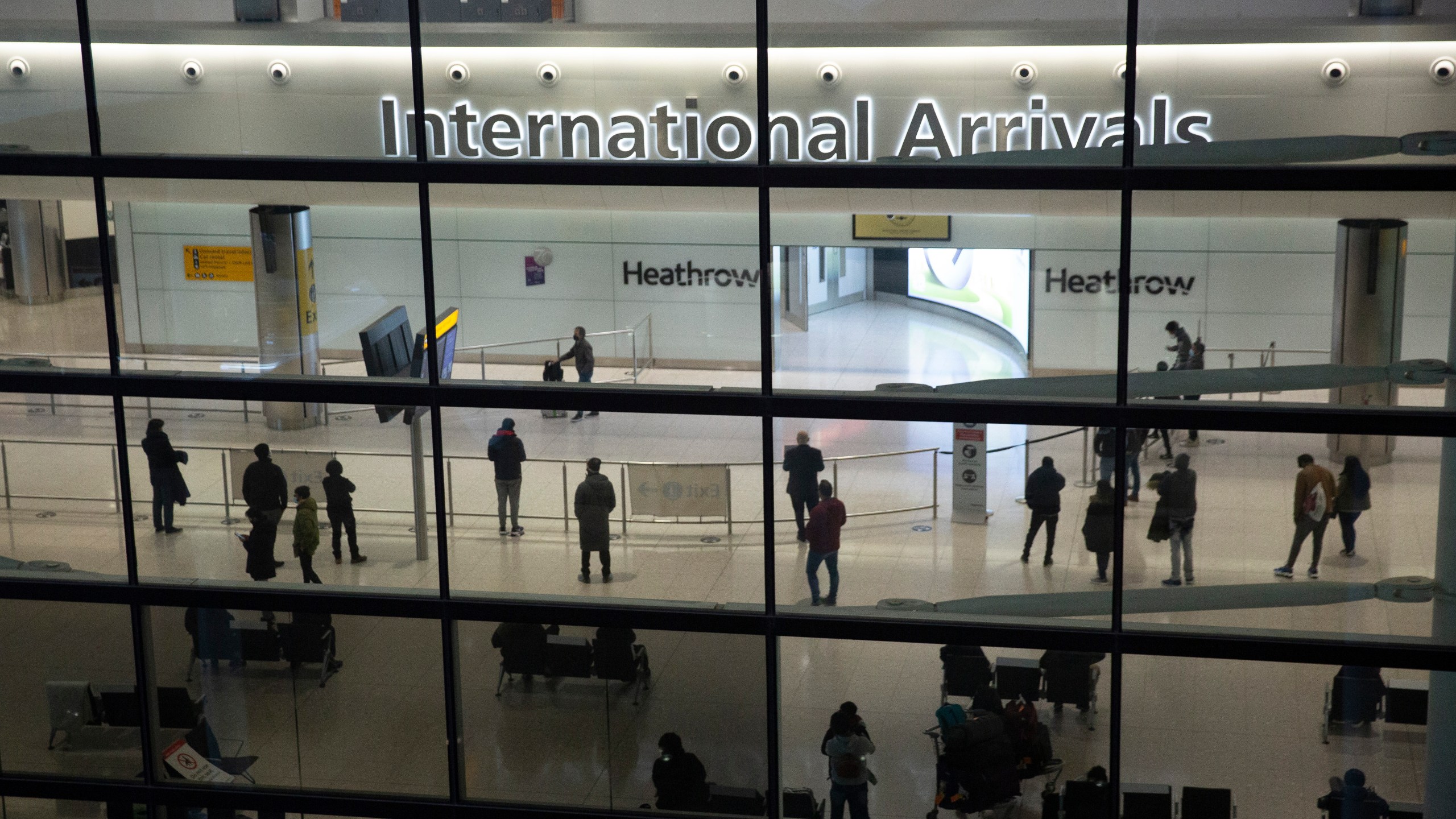 In this file photo dated Tuesday, Jan. 26, 2021, people in the International Arrivals area at Heathrow Airport in London, during England's coronavirus lockdown. The British government has said that starting upcoming Monday Aug. 2, 2021, fully vaccinated travellers from the United States and much of Europe will be able to enter England without the need for quarantining. (AP Photo/Matt Dunham, FILE)