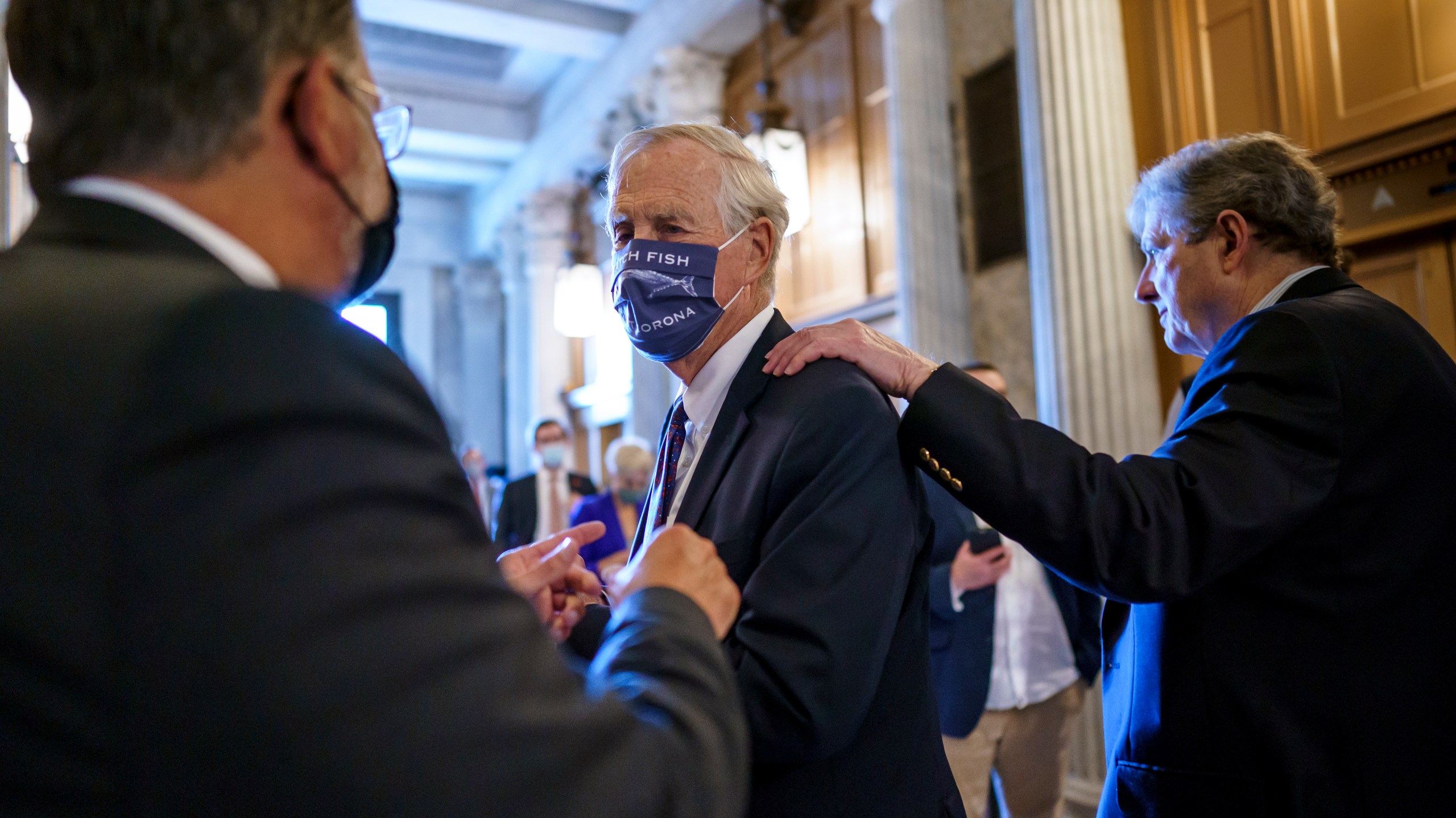 Sen. Angus King, I-Maine, center, speaks with Sen. Gary Peters, D-Mich., left, while Sen. John Kennedy, R-La., walks by at right, as the Senate votes to formally begin debate on a roughly $1 trillion infrastructure plan, a process that could take several days, at the Capitol in Washington, Friday, July 30, 2021. (AP Photo/J. Scott Applewhite)