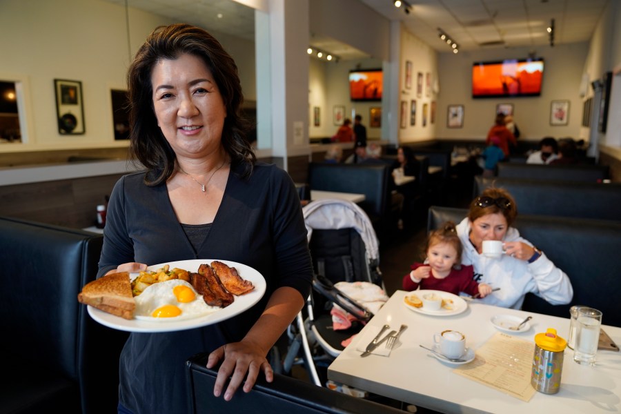 Jeannie Kim holds her popular bacon and eggs breakfast at her restaurant in San Francisco on Friday, July 30, 2021. Thanks to a reworked menu and long hours, Jeannie Kim managed to keep her San Francisco restaurant alive during the coronavirus pandemic. That makes it all the more frustrating that she fears her breakfast-focused diner could be ruined within months by new rules that could make one of her top menu items — bacon — hard to get in California. (AP Photo/Eric Risberg)