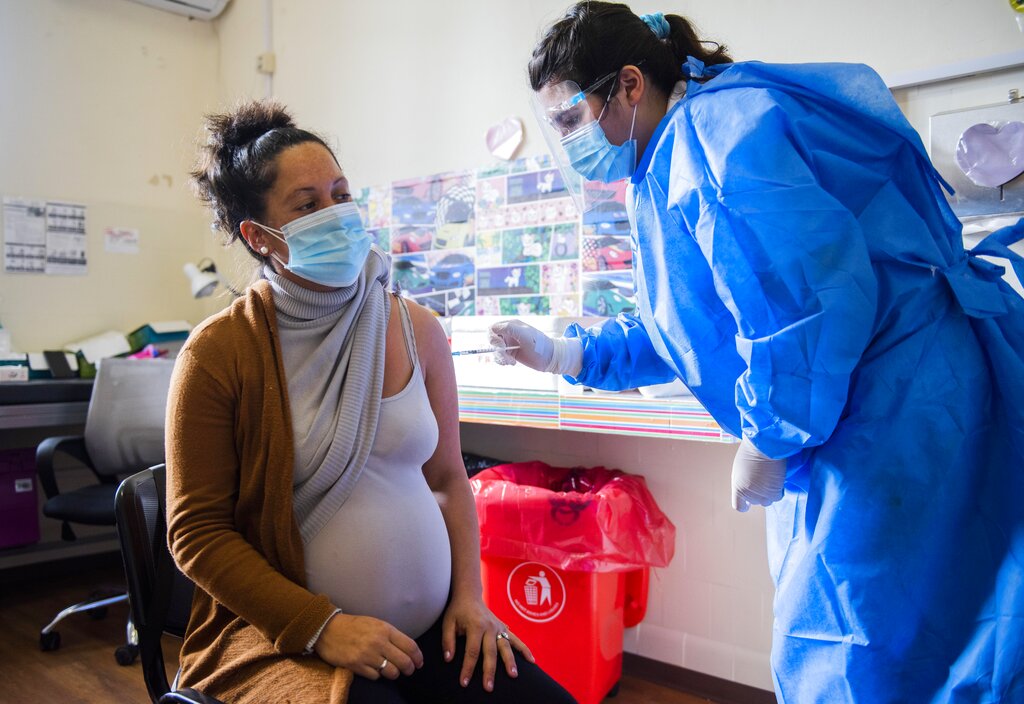 In this Wednesday, June 9, 2021 file photo, A nurse gives a shot of the Pfizer vaccine for COVID-19 to a pregnant woman in Montevideo, Uruguay. (AP Photo/Matilde Campodonico, File)