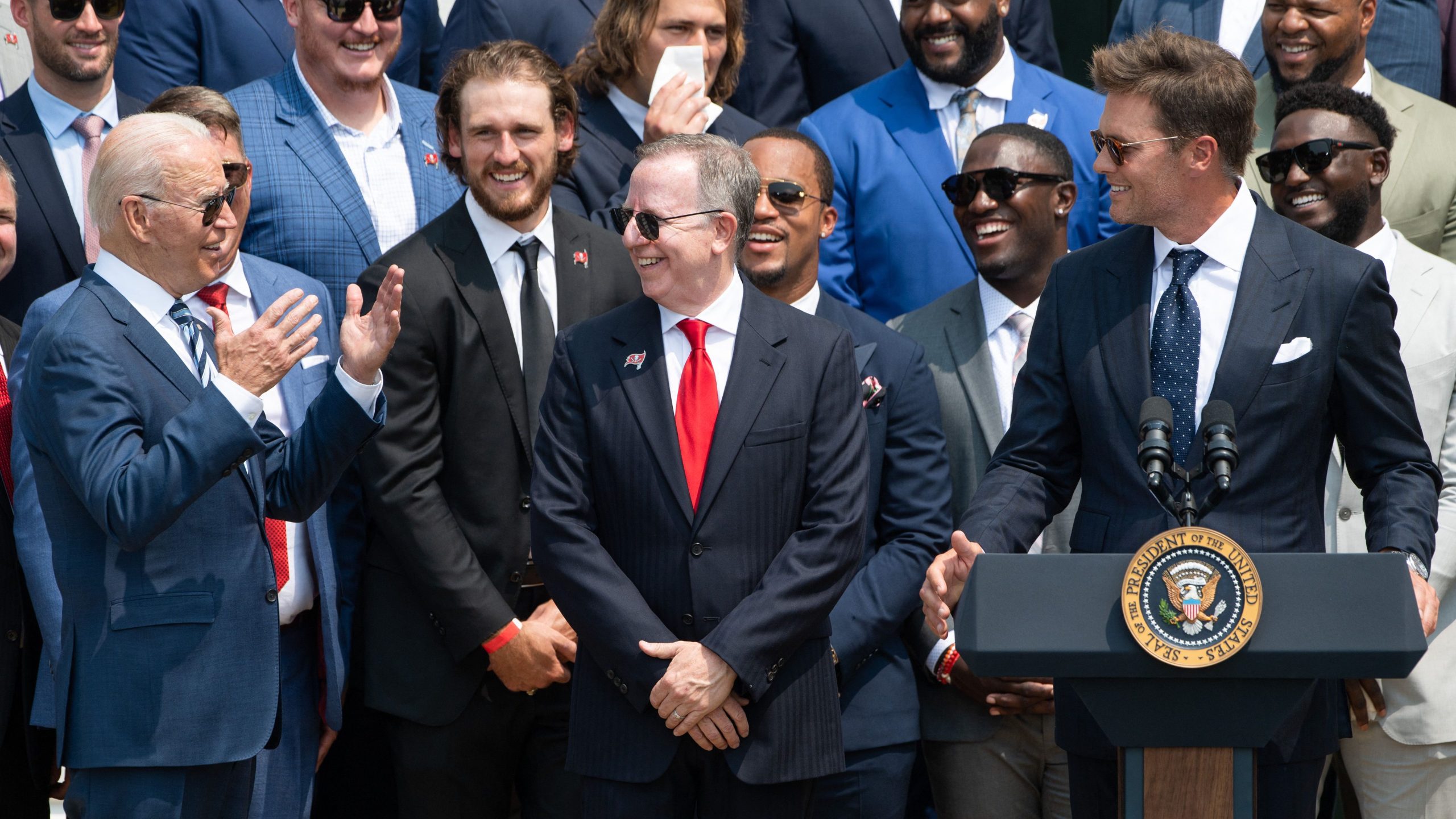 Tampa Bay Buccaneers quarterback Tom Brady, right, speaks alongside President Joe Biden and team owner Bryan Glazer, center, during a ceremony honoring the Tampa Bay Buccaneers NFL football team for their Super Bowl LV Championship on the South Lawn of the White House on July 20, 2021. (Saul Loeb / AFP / Getty Images)