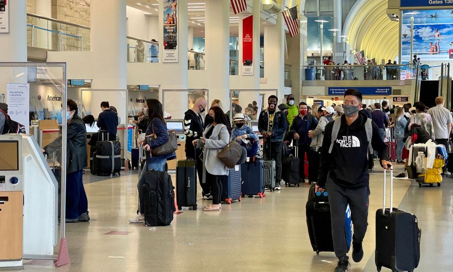 Passengers wait in line at the American Airlines checkin counters at the Los Angeles International Airport (LAX) on April 24, 2021. (DANIEL SLIM/AFP via Getty Images)