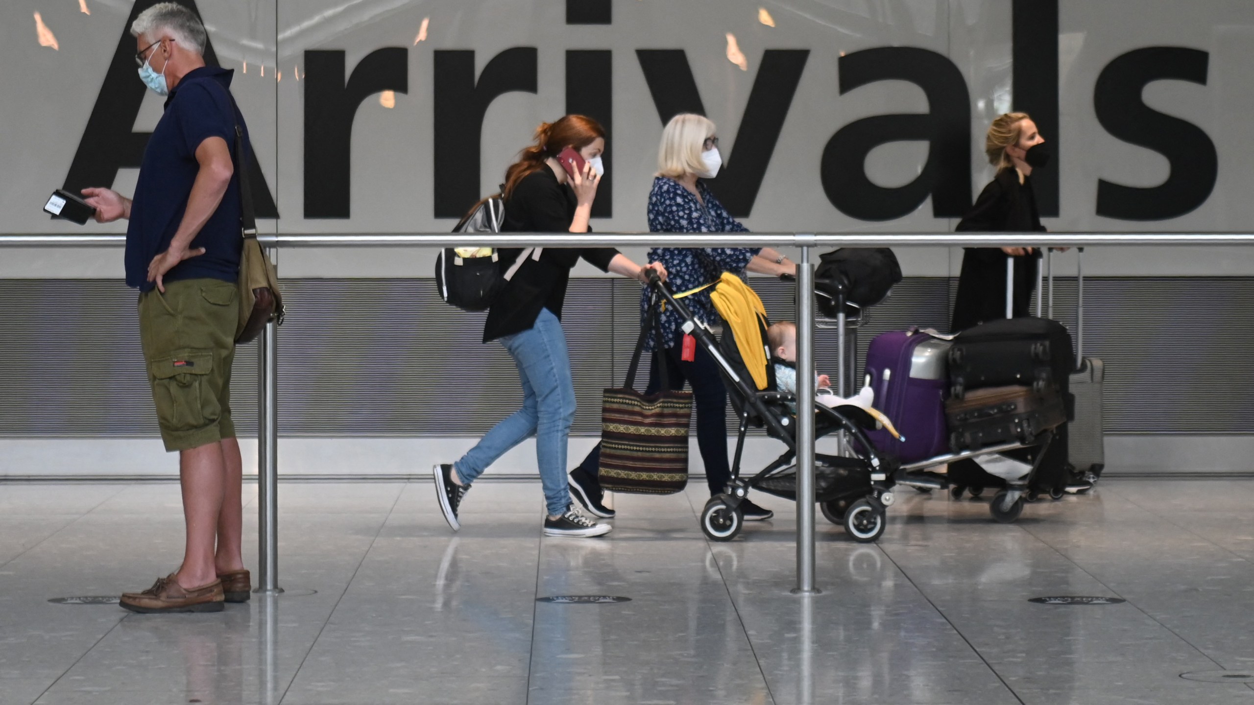 Travelers walk through Heathrow airport in London, on June 3, 2021. (DANIEL LEAL-OLIVAS/AFP via Getty Images)