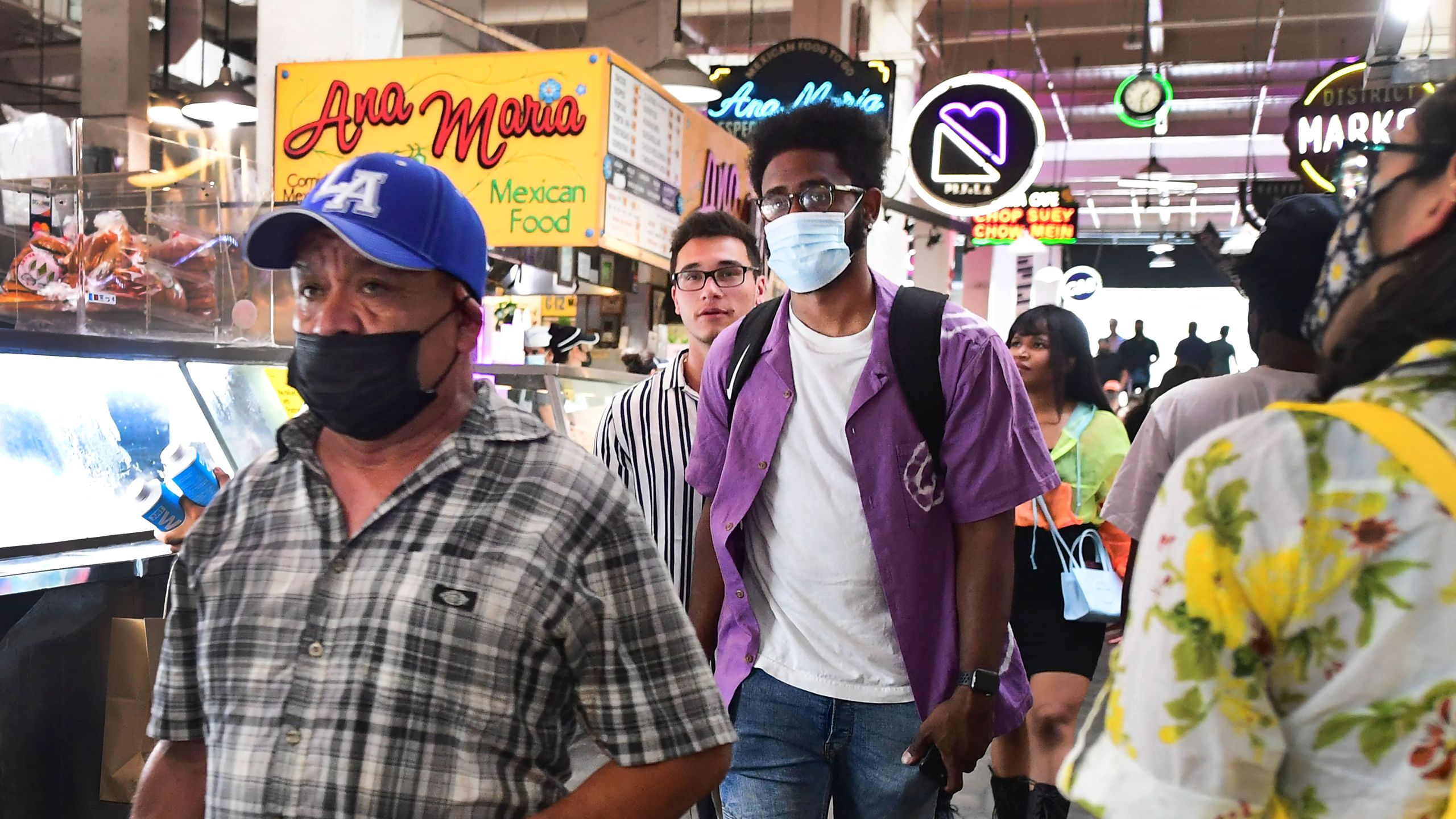 Masked and unmasked people make their way through Grand Central Market in Los Angeles, California on June 29, 2021. (Frederic J. Brown/AFP via Getty Images)