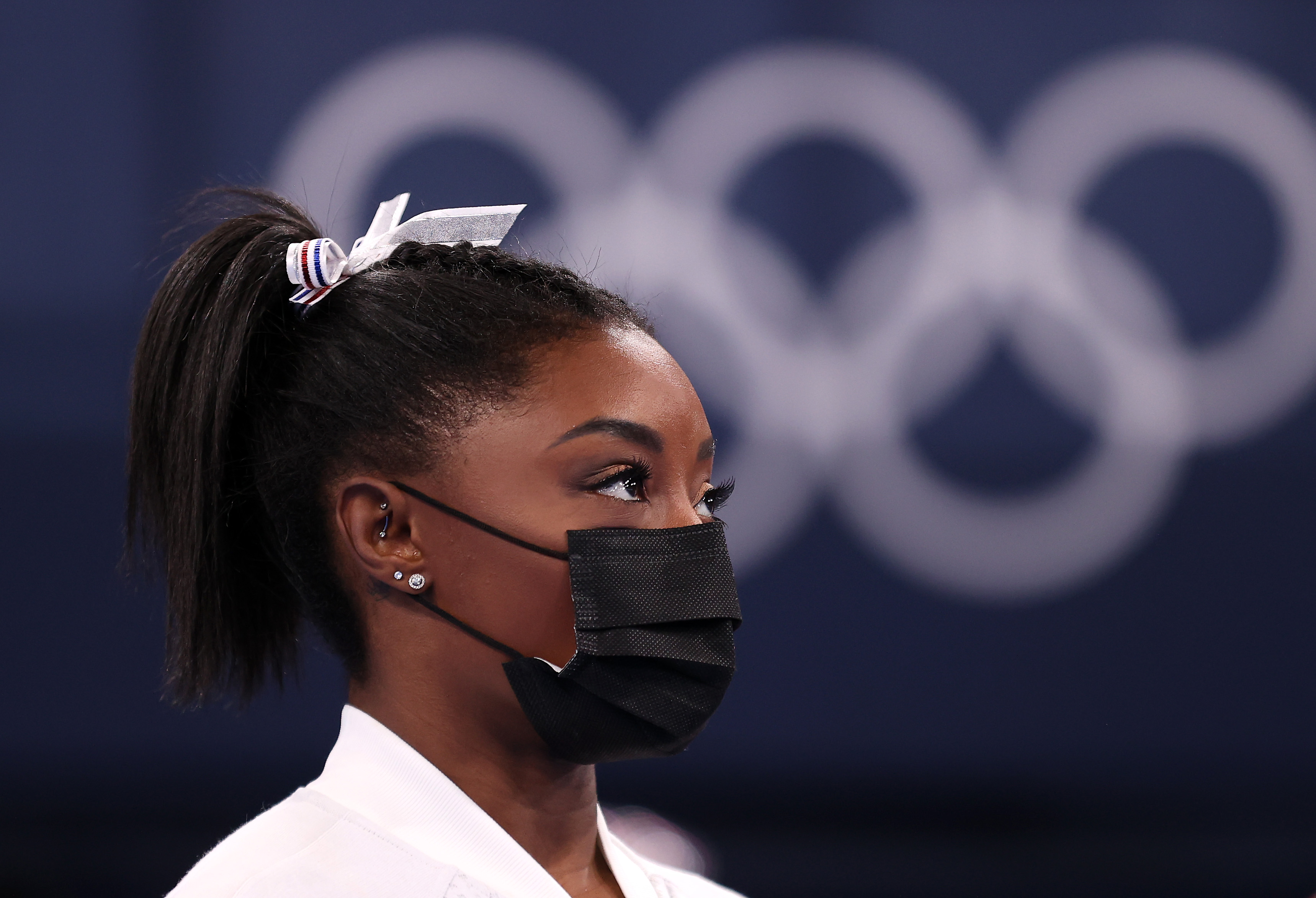 Simone Biles of Team United States watches her team perform on bars after pulling out of the competition after only competing on the vault during the Women's Team Final on day four on day four of the Tokyo 2020 Olympic Games at Ariake Gymnastics Centre on July 27, 2021, in Tokyo, Japan.(Laurence Griffiths/Getty Images)