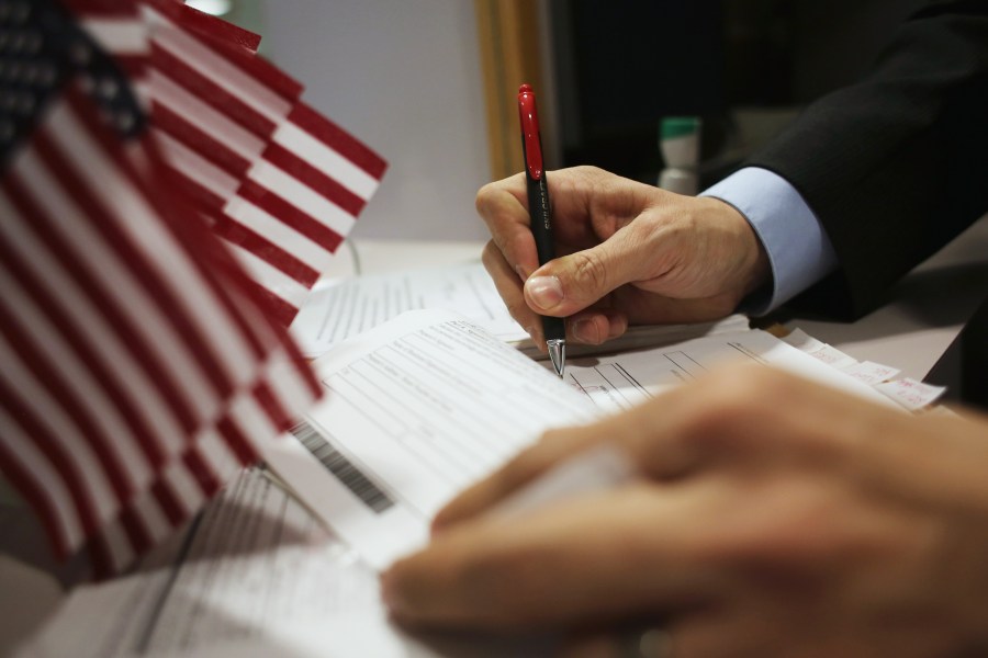 This file photo shows an official signing applications at the U.S. Citizenship and Immigration Services district office on Jan. 29, 2013, in New York City. (John Moore/Getty Images)