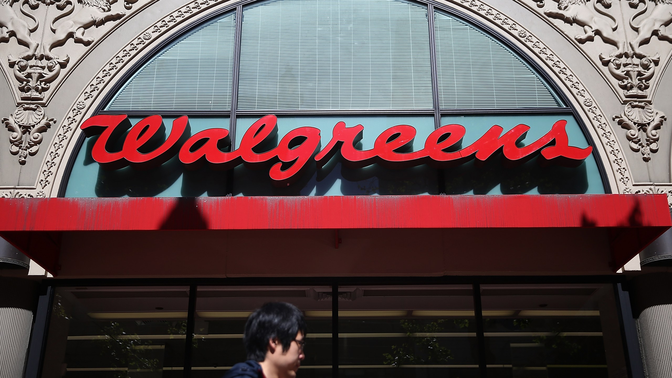 This file photo shows a pedestrian walking by a Walgreens store in San Francisco on April 5, 2016. (Justin Sullivan/Getty Images)