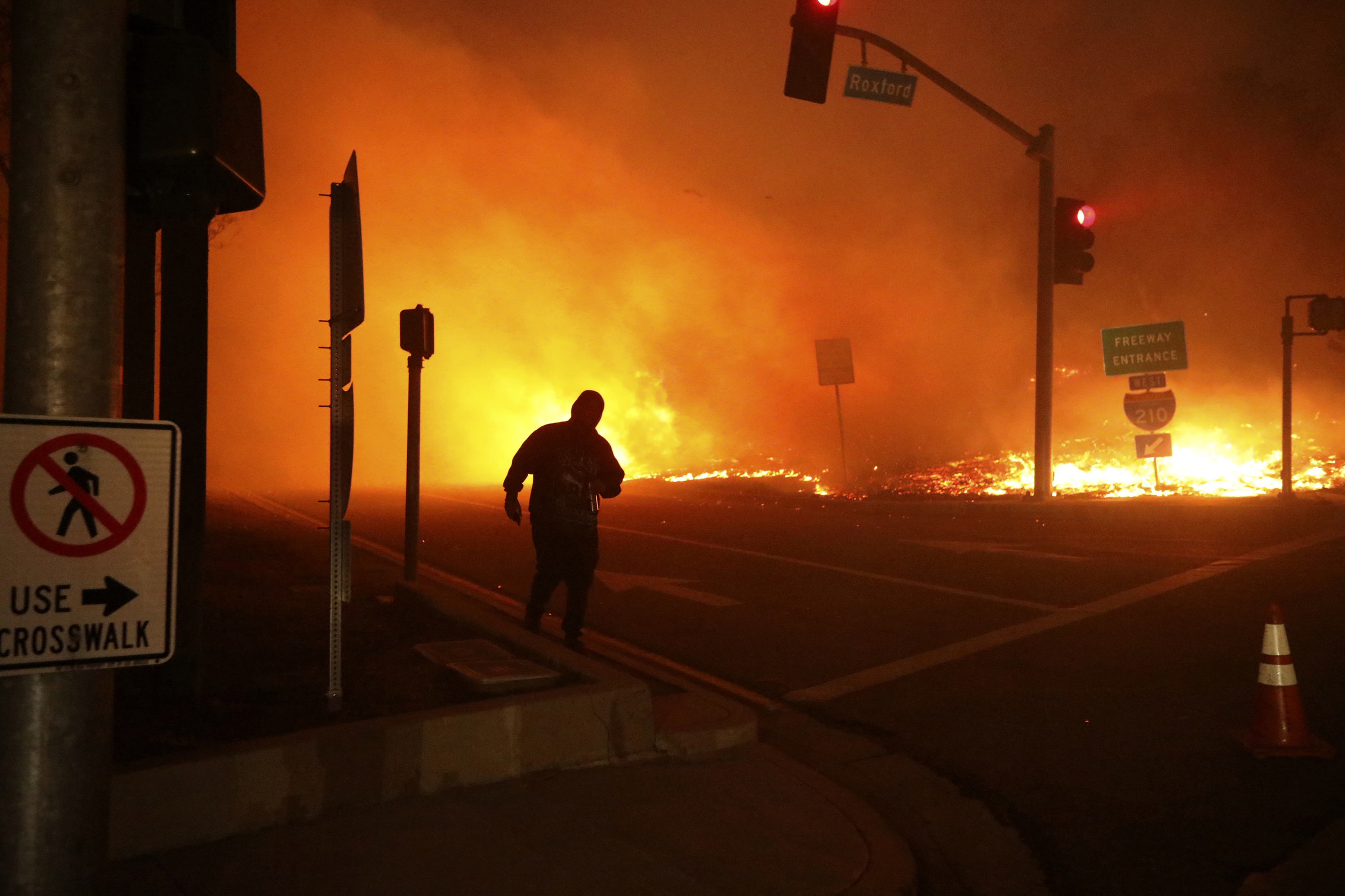 In this Oct. 11, 2019, photo, a bystander watches the Saddleridge Fire in Sylmar, Calif. (AP Photo/David Swanson)