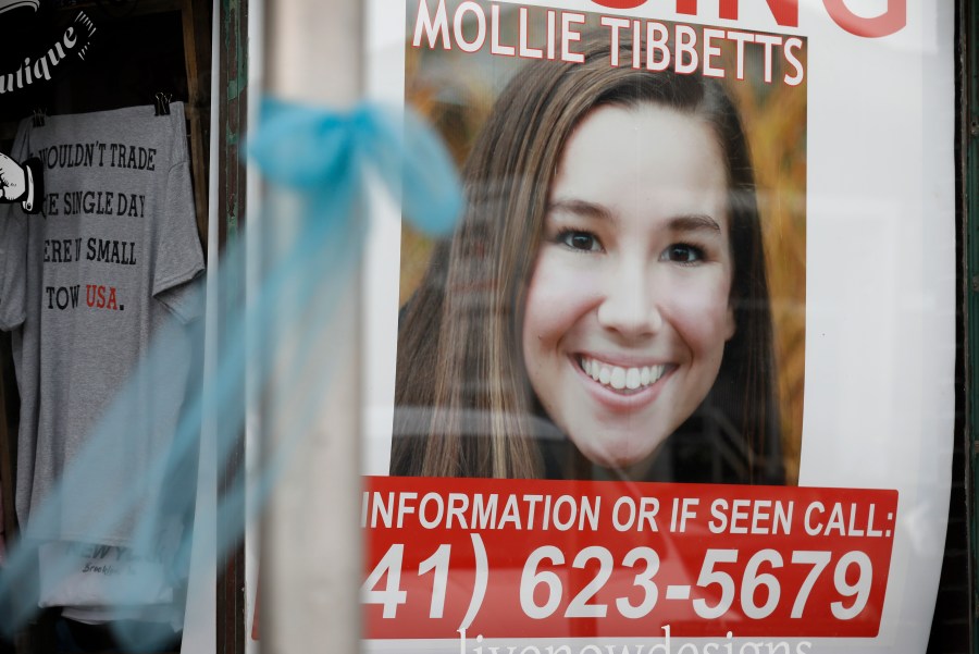 In this Aug. 21, 2018, photo, a poster for missing University of Iowa student Mollie Tibbetts hangs in the window of a local business in Brooklyn, Iowa. (AP Photo/Charlie Neibergall)