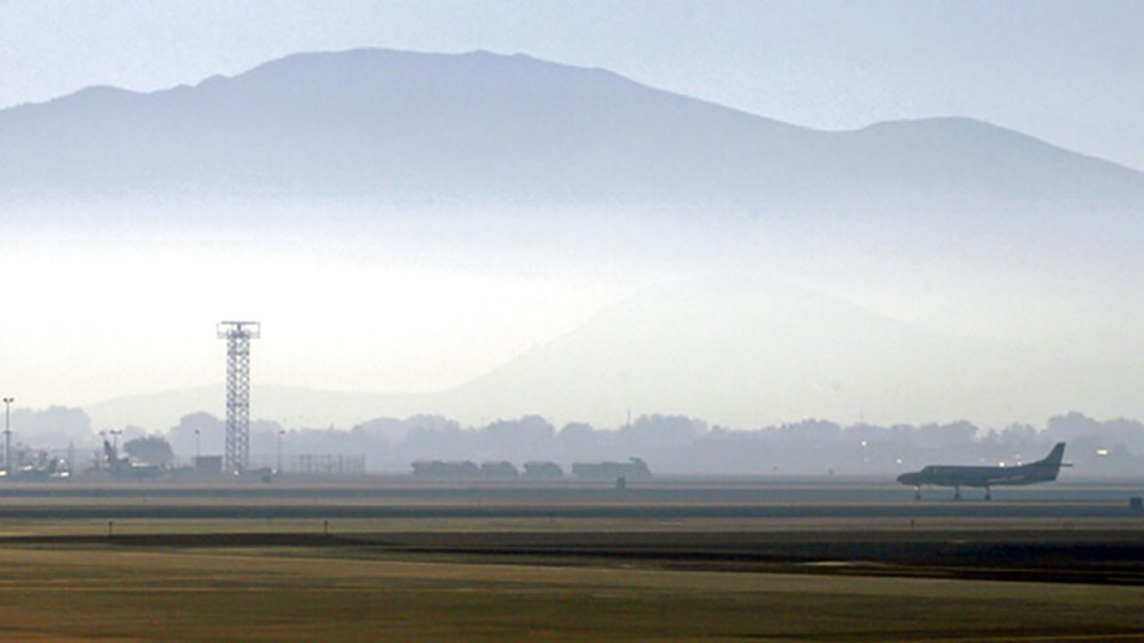 In this Sept. 24, 2014 file photo, smoke hangs over Reno-Tahoe International Airport as a plane takes off in Reno, Nev. (AP Photo/Martha Irvine, File)