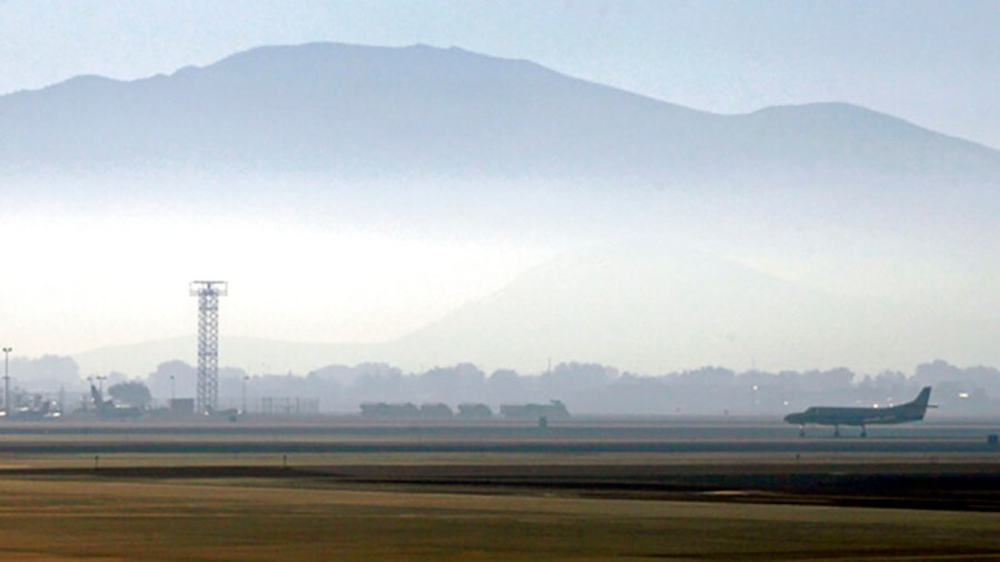 In this Sept. 24, 2014 file photo, smoke hangs over Reno-Tahoe International Airport as a plane takes off in Reno, Nev. (AP Photo/Martha Irvine, File)