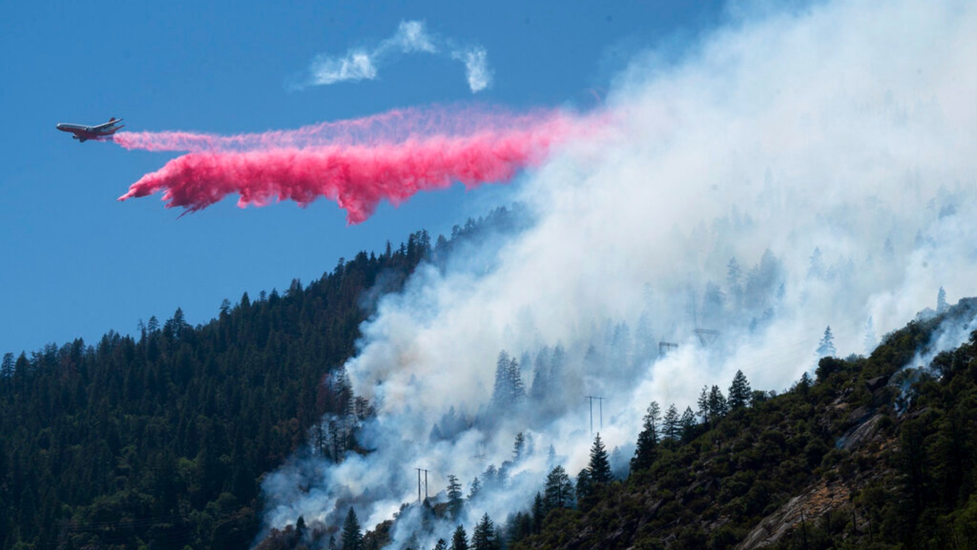 An air tanker drops fire retardant to battle the Dixie Fire in the Feather River Canyon in Plumas County, Calif., Wednesday, July 14, 2021. (Paul Kitagaki Jr./The Sacramento Bee via AP)