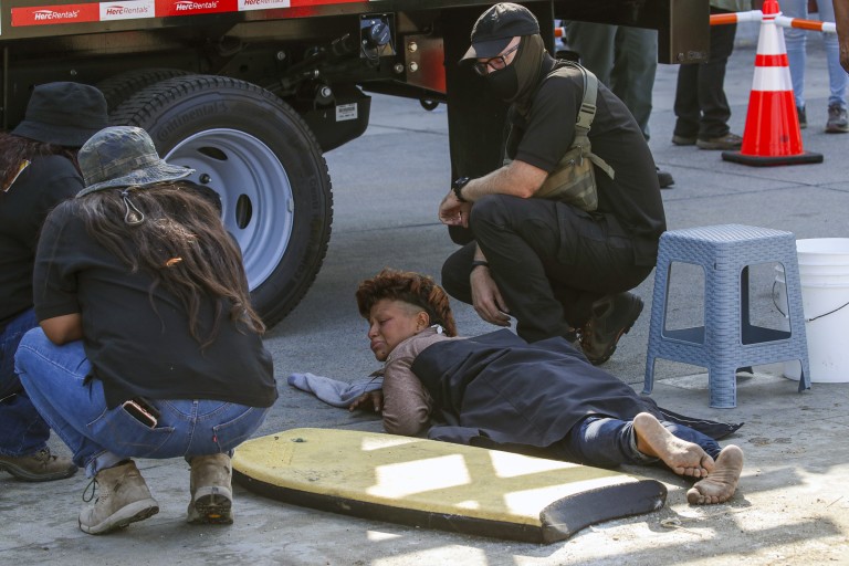 A homeless person wakes up as L.A. conducts a major cleanup of homeless encampments on the Venice boardwalk on July 9, 2021. (Irfan Khan/Los Angeles Times)