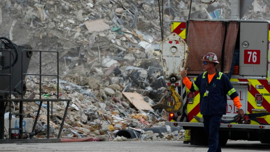 Crews work in the rubble of the demolished section of the Champlain Towers South building, as removal and recovery work continues at the site of the partially collapsed condo building, on Monday, July 12, 2021, in Surfside, Fla.(AP Photo/Rebecca Blackwell)