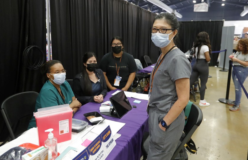 Maxim Healthcare Services site manager Karen Hsu, right, with her team at the 2021 O.C. Fair for any walk-up guests who qualify for a vaccine. (Don Leach / L.A. Times Community News )