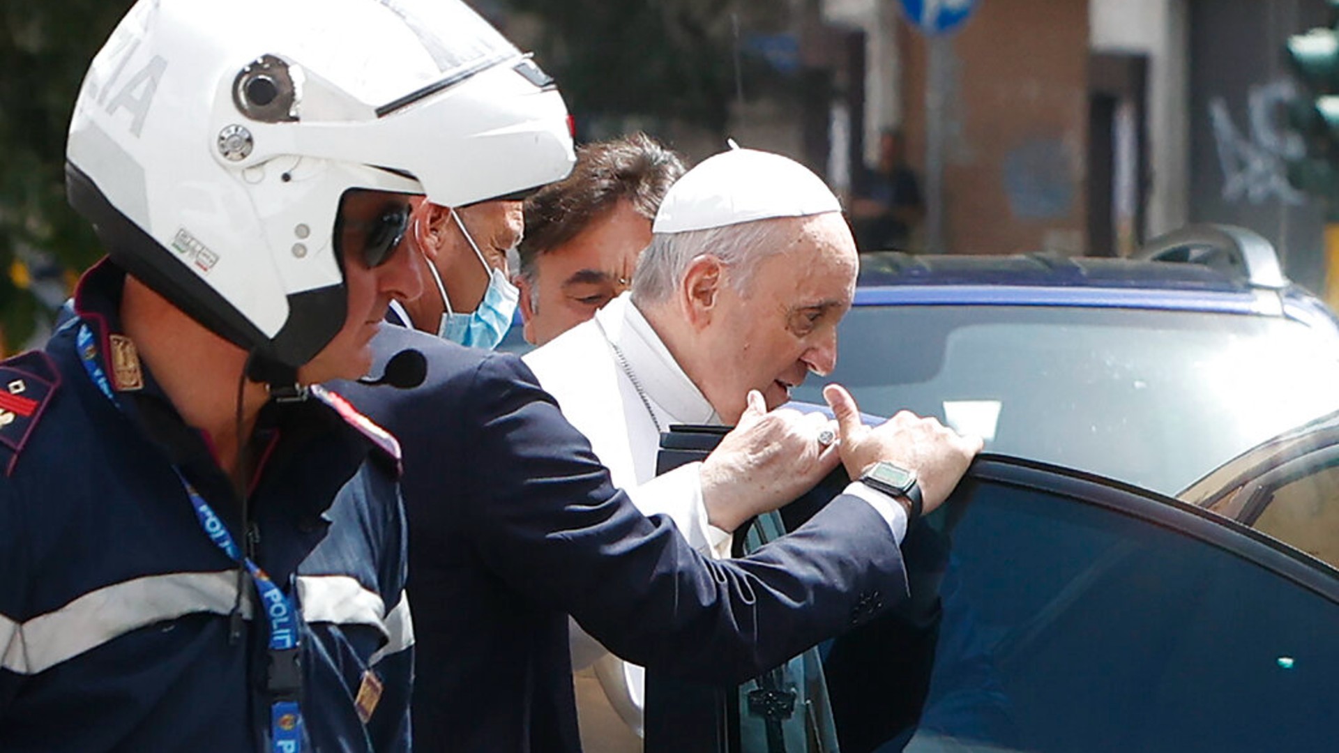 Pope Francis stops to greet police that escorted him as he arrives at the Vatican after leaving the hospital on his Ford, 10 days after undergoing planned surgery to remove half his colon Wednesday, July 14, 2021. (AP Photo/Riccardo De Luca)