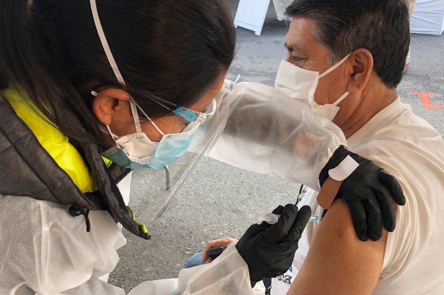 In this Feb. 8, 2021 file photo, a man receives a COVID-19 vaccine shot from a health care worker at a vaccination site in the Mission district of San Francisco. (AP Photo/Haven Daley)