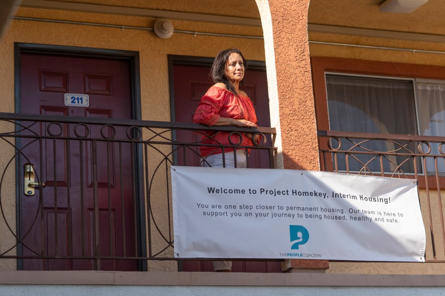 In this Wednesday, June 30, 2021, photo Veronica Perez poses outside her new home at the Mollie Mason Project Homekey site in Los Angeles. (AP Photo/Damian Dovarganes)