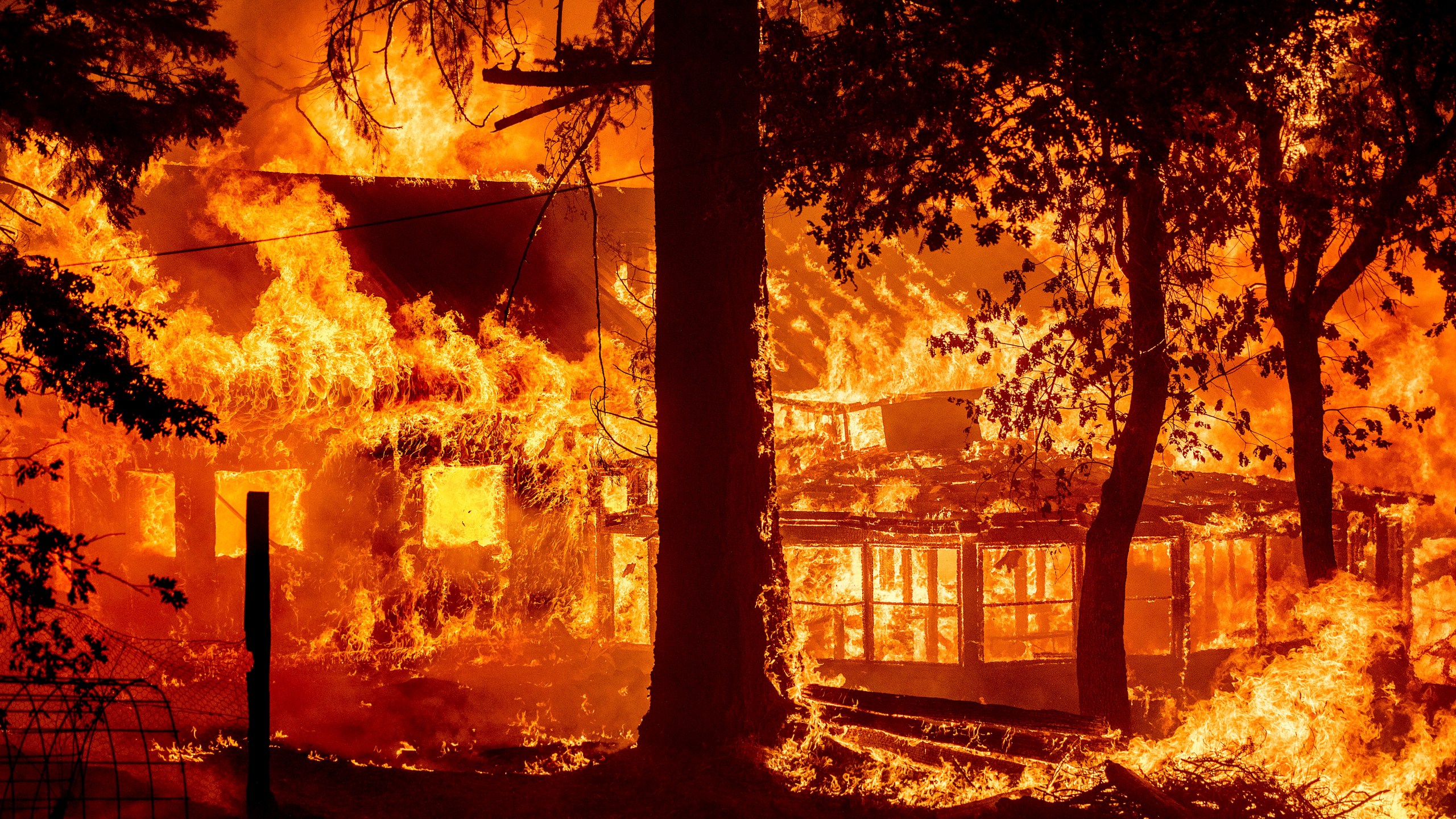 Flames from the Dixie Fire consume a home in the Indian Falls community of Plumas County, Calif., Saturday, July 24, 2021. (AP Photo/Noah Berger)