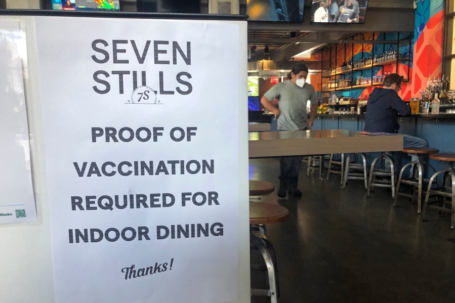 A proof of vaccination sign is posted at a bar in San Francisco on Thursday, July 29, 2021. Until now, many employers had taken a passive approach to their unvaccinated workers, relying outreach and incentives. But that has been shifting, with vaccine mandates gaining momentum. (AP Photo/Haven Daley)