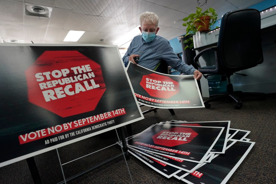 Volunteer Merle Canfield assembles yard signs against the Sept. 14, recall election of Gov. Gavin Newsom, at the Fresno County Democratic Party headquarters in Fresno, Calif., Thursday July 29, 2021. While Democratic registration almost doubles that of Republicans in the state, Democratic Party leaders fear Republicans appear more eager to vote. (AP Photo/Rich Pedroncelli))