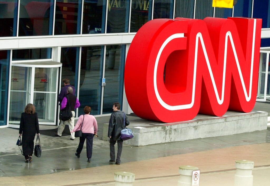 This Jan. 17, 2001 file photo shows pedestrians entering CNN Center, the headquarters for CNN, in downtown Atlanta. CNN has fired three employees for violating its policy that employees must be vaccinated against the COVID-19 virus. The firings were revealed Thursday, Aug. 5, 2021 as part of a memo sent by Jeff Zucker, chairman of WarnerMedia news and sports. (AP Photo/Ric Feld, File)