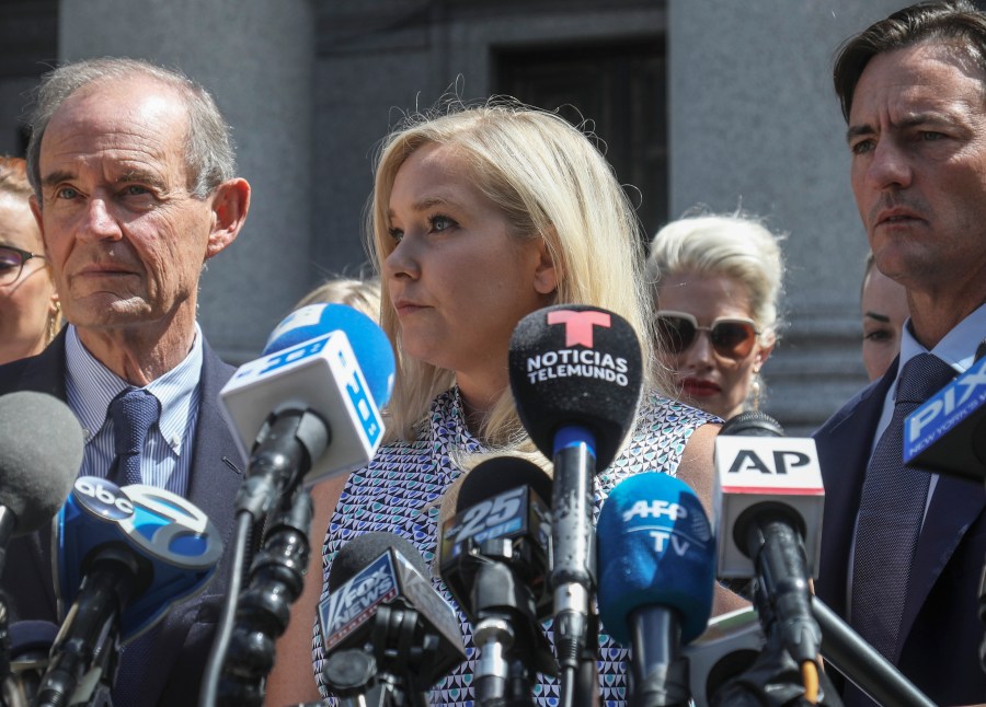 In this Aug. 27, 2019 file photo, Virginia Giuffre, center, who says she was trafficked by sex offender Jeffrey Epstein, holds a news conference outside a Manhattan court in New York. (Bebeto Matthews/AssociatedPress)