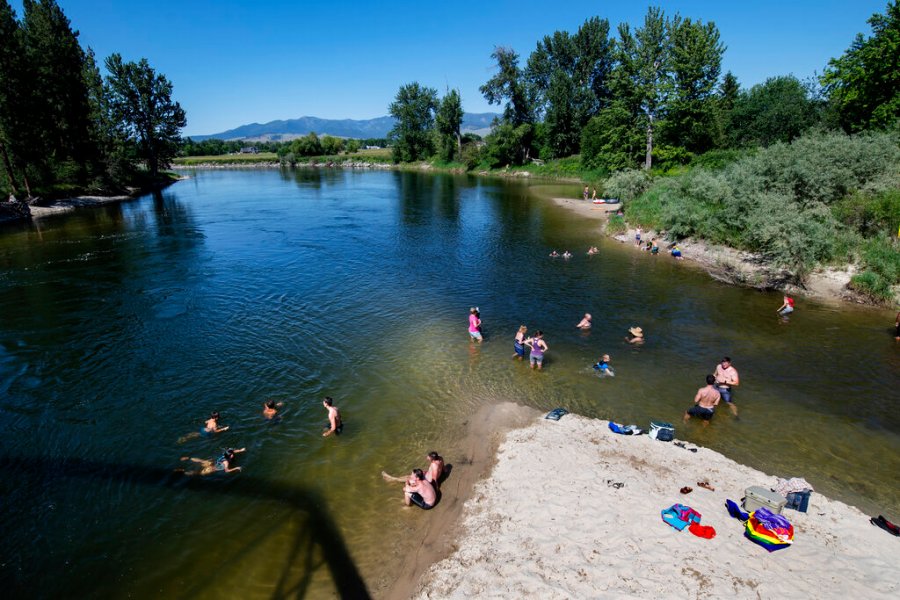 In this June 30, 2021 file photo Missoulians cool off in the Bitterroot River as temperatures crested 100 degrees Fahrenheit in Missoula, Mont. (AP Photo/Tommy Martino, File)