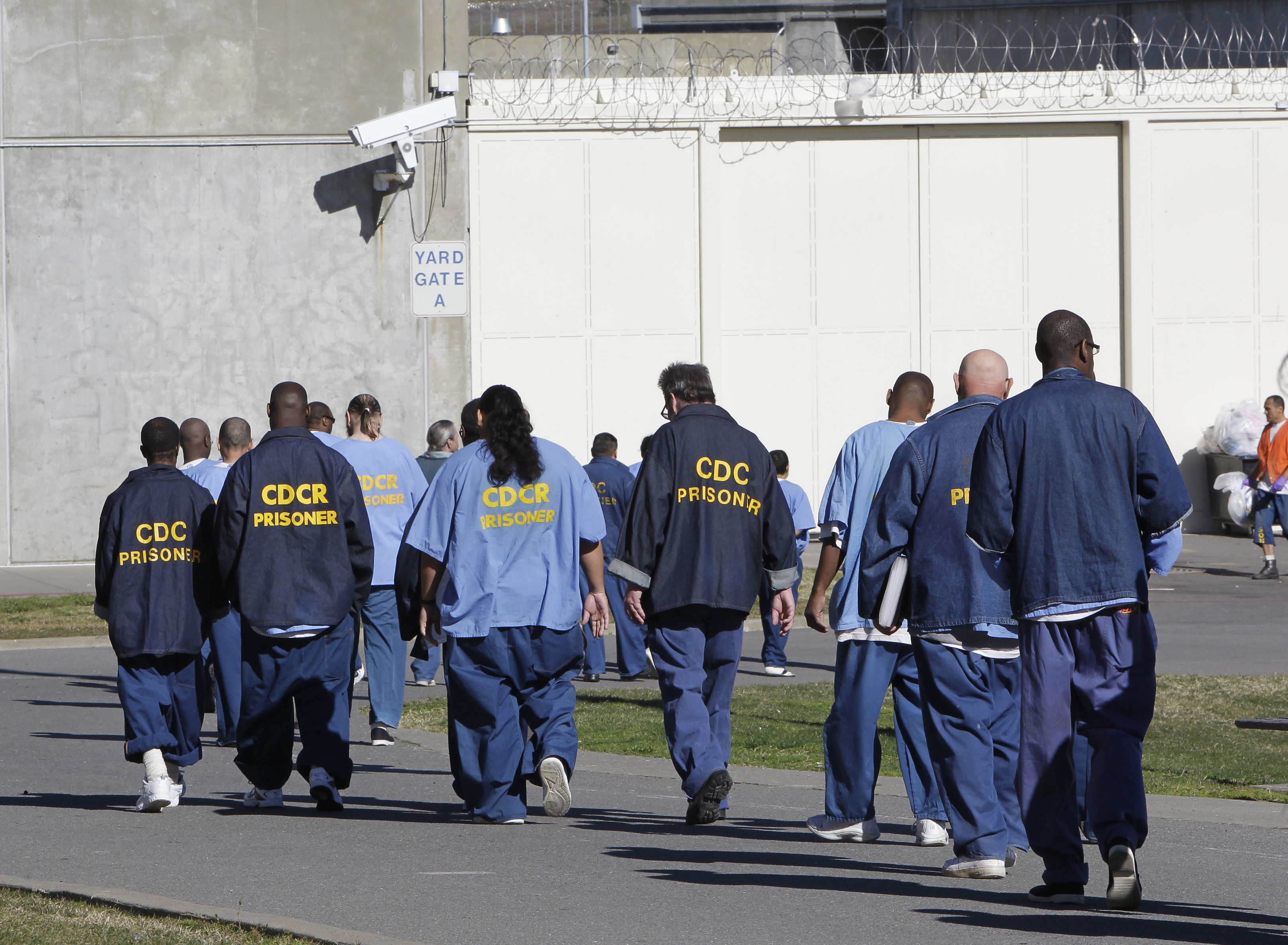 In this Feb. 26, 2013, file photo, inmates walk through the exercise yard at California State Prison Sacramento, near Folsom, Calif. (AP Photo/Rich Pedroncelli, File)