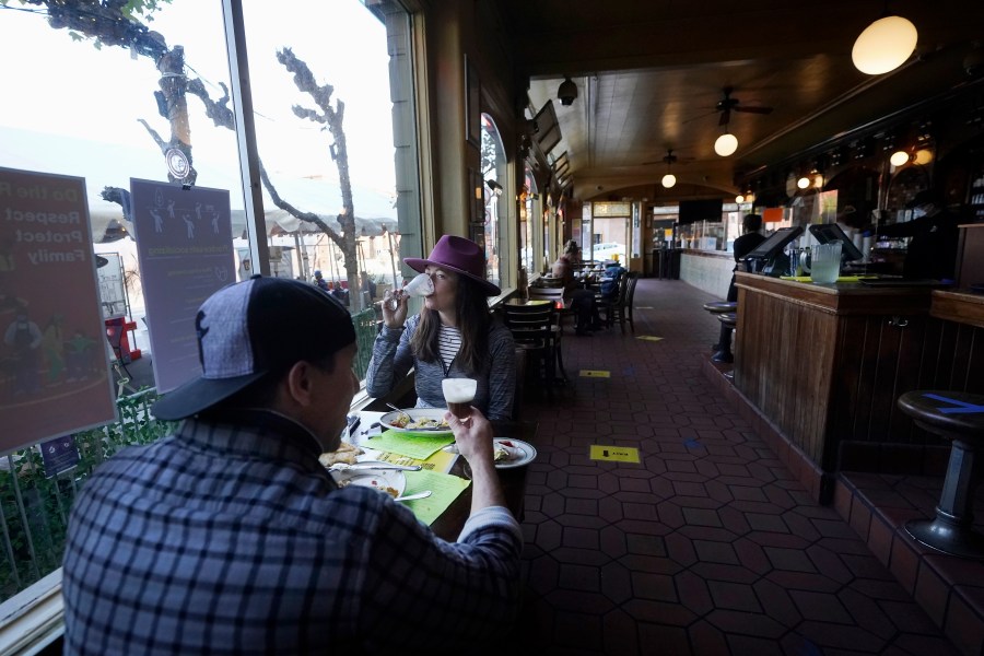 In this Nov. 12, 2020, file photo, diners Mitchell Bryant, left, and Darla Scott eat inside at the Buena Vista Cafe amid the coronavirus outbreak in San Francisco. San Francisco will require proof of full vaccination against COVID-19 for a number of indoor activities such as visiting restaurants, bars and gyms. A city supervisor confirmed the new mandate shortly before Mayor London Breed was scheduled to hold a news conference Thursday, Aug. 12, 2021.(AP Photo/Jeff Chiu, File)